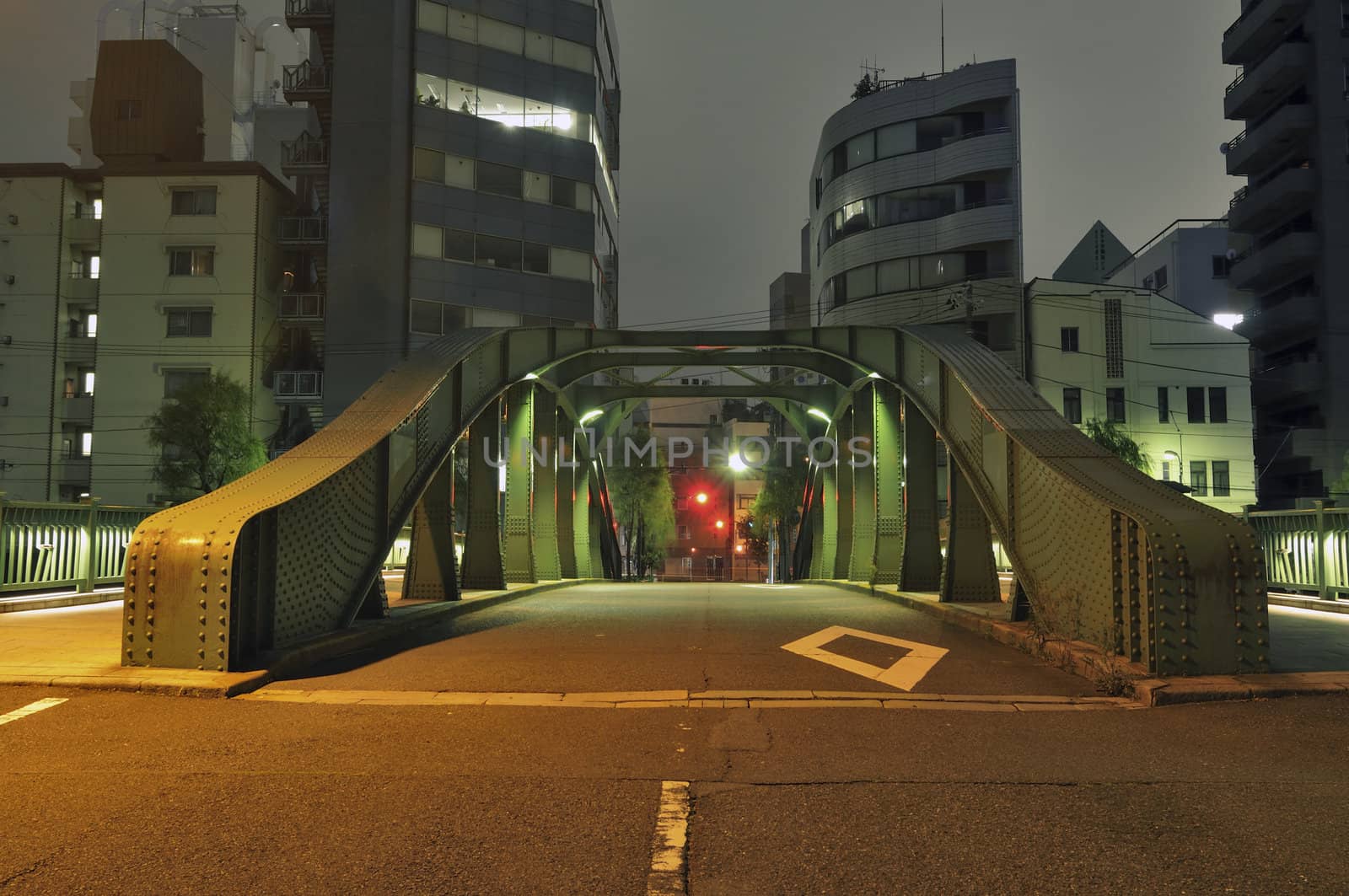 night street passing through metallic arc bridge in Tokyo