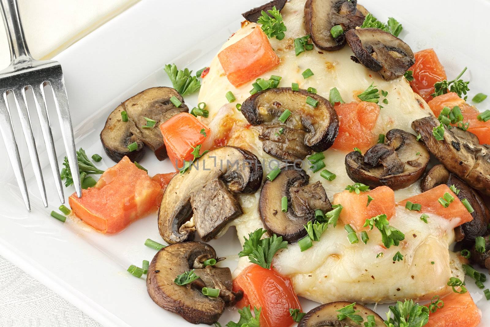 Chicken baked with baby portabella mushrooms, tomatoes, and mozzarella cheese. Garnished with chives and parsley.