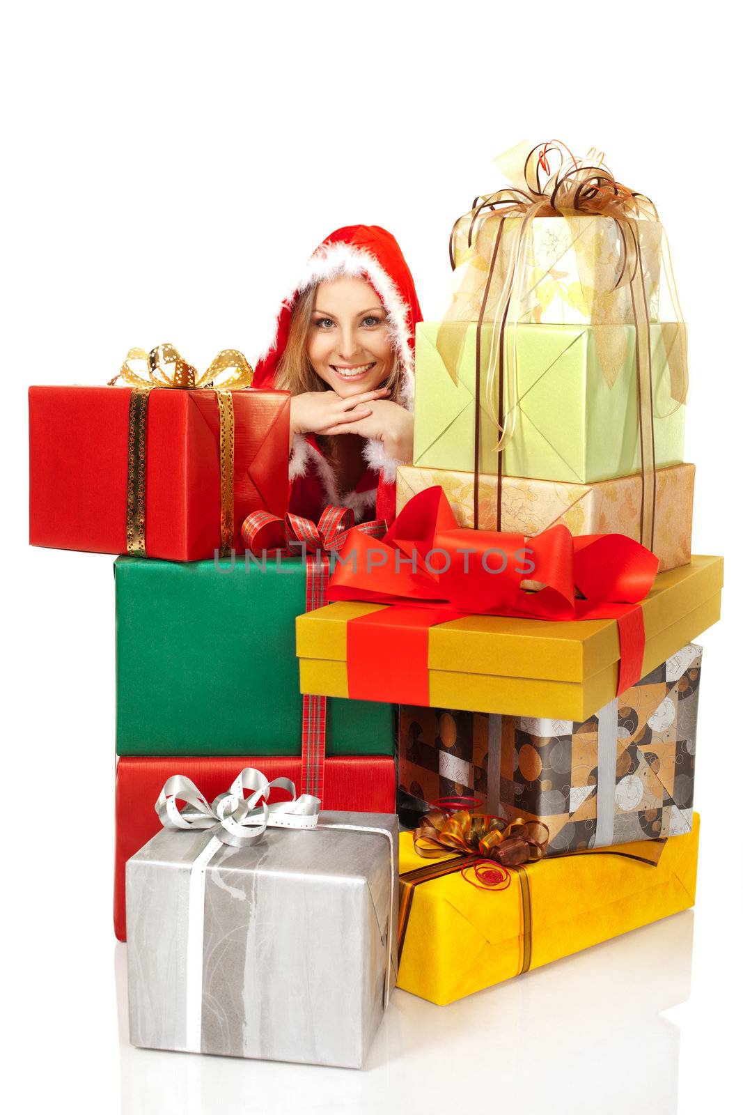 Smiling female with christmas costume smiling at camera behind pile of colorful gift boxes