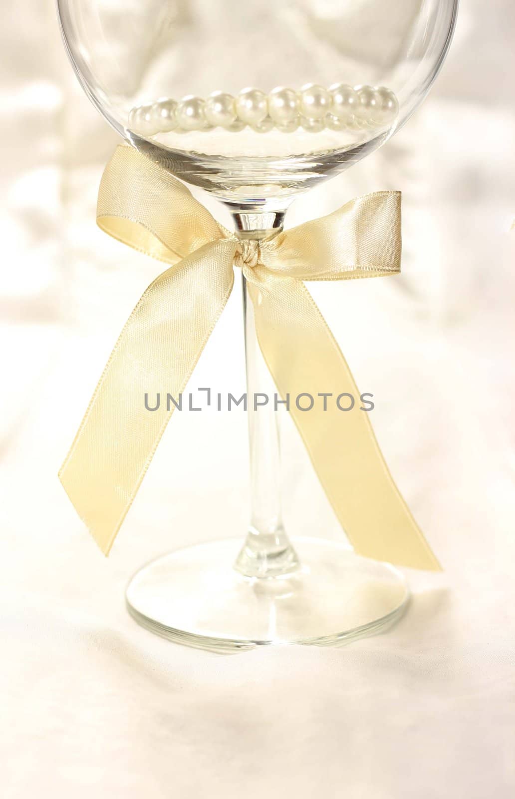 Wineglass with ribbon on silk fair background by Kristina_Usoltseva