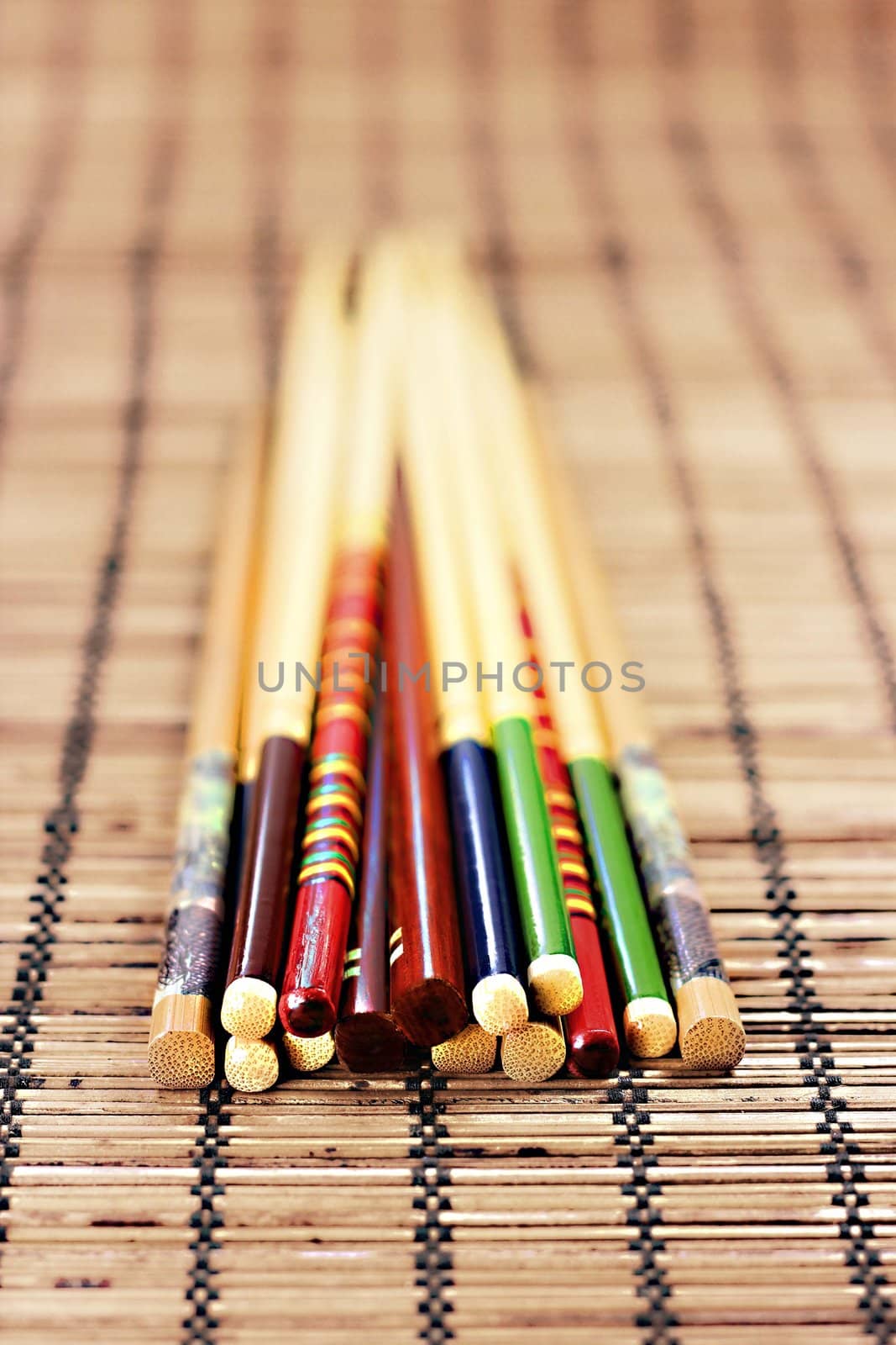 Closeup of various colorful chopsticks on bamboo background