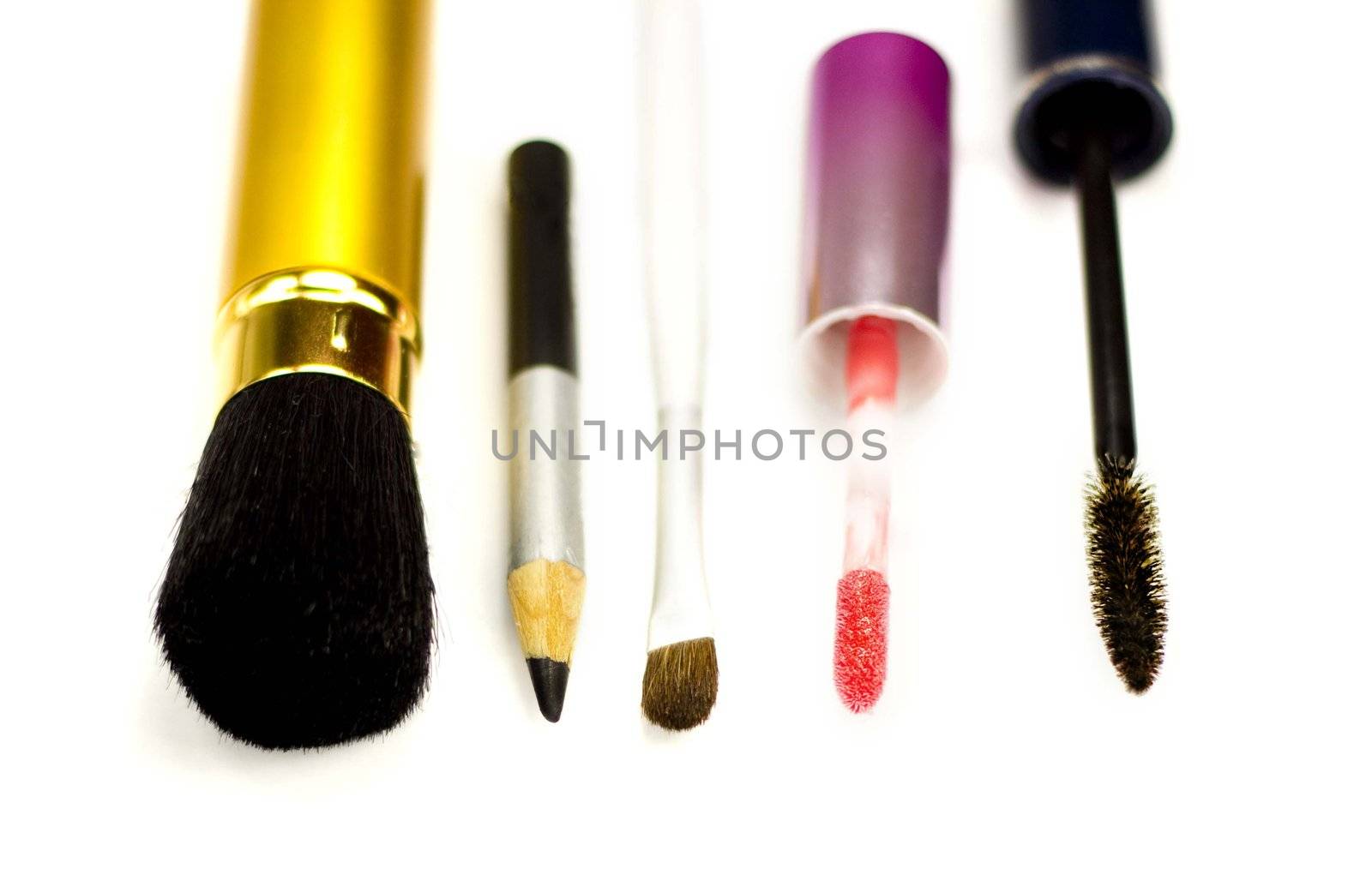 Close-up of eyeliner, applicator for lip gloss and brushes for eye-shadows, brusher and mascara on a white background