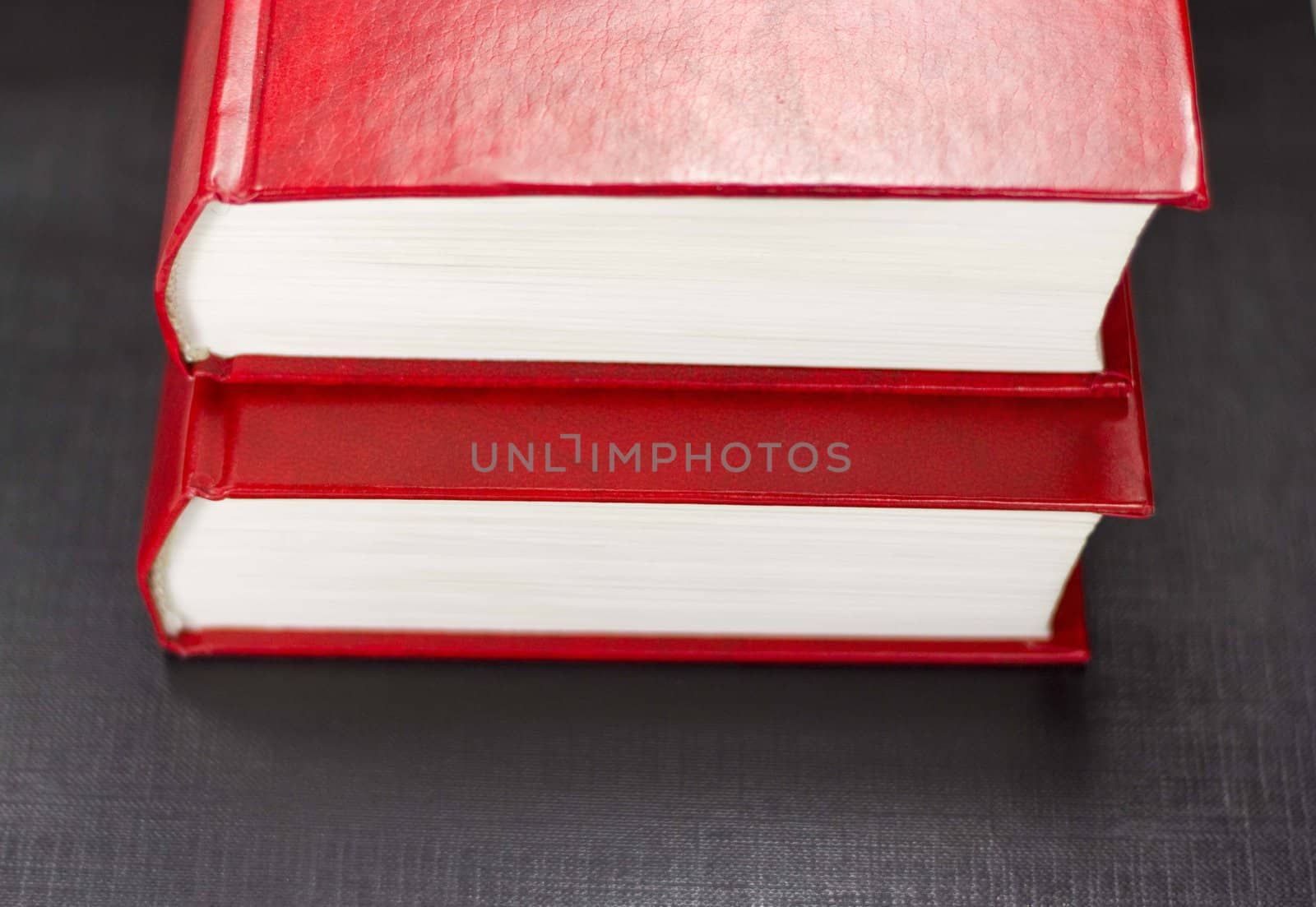 Side view of two red books on a black background