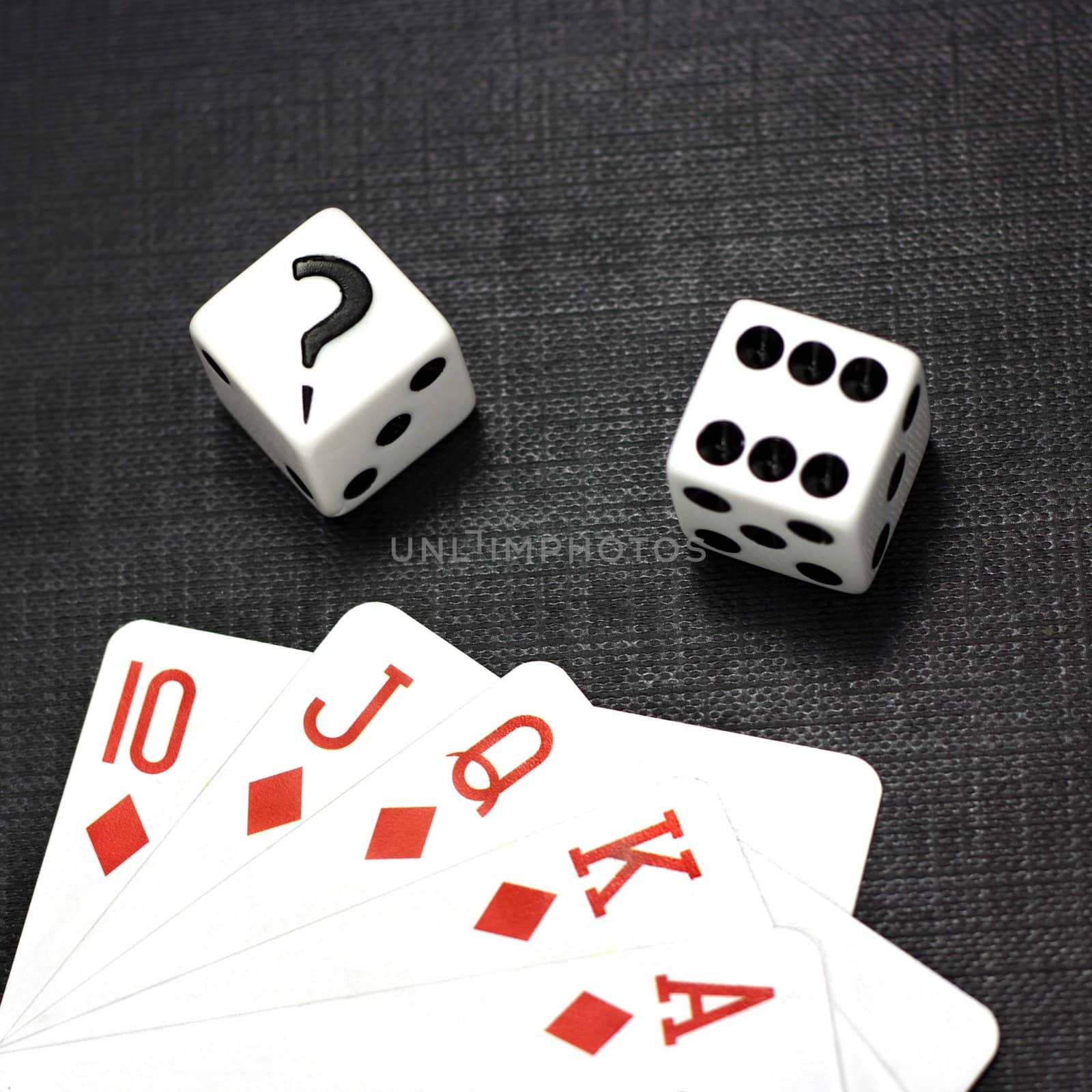 Two white dices and playing cards on a black background