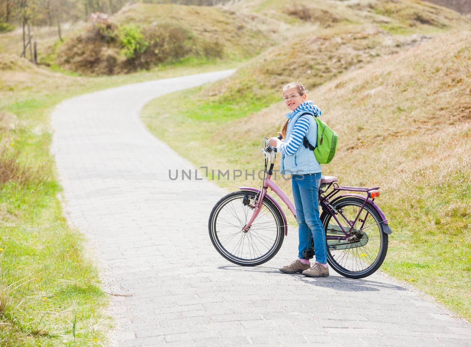 Cute girl with the bike in the park on a spring day