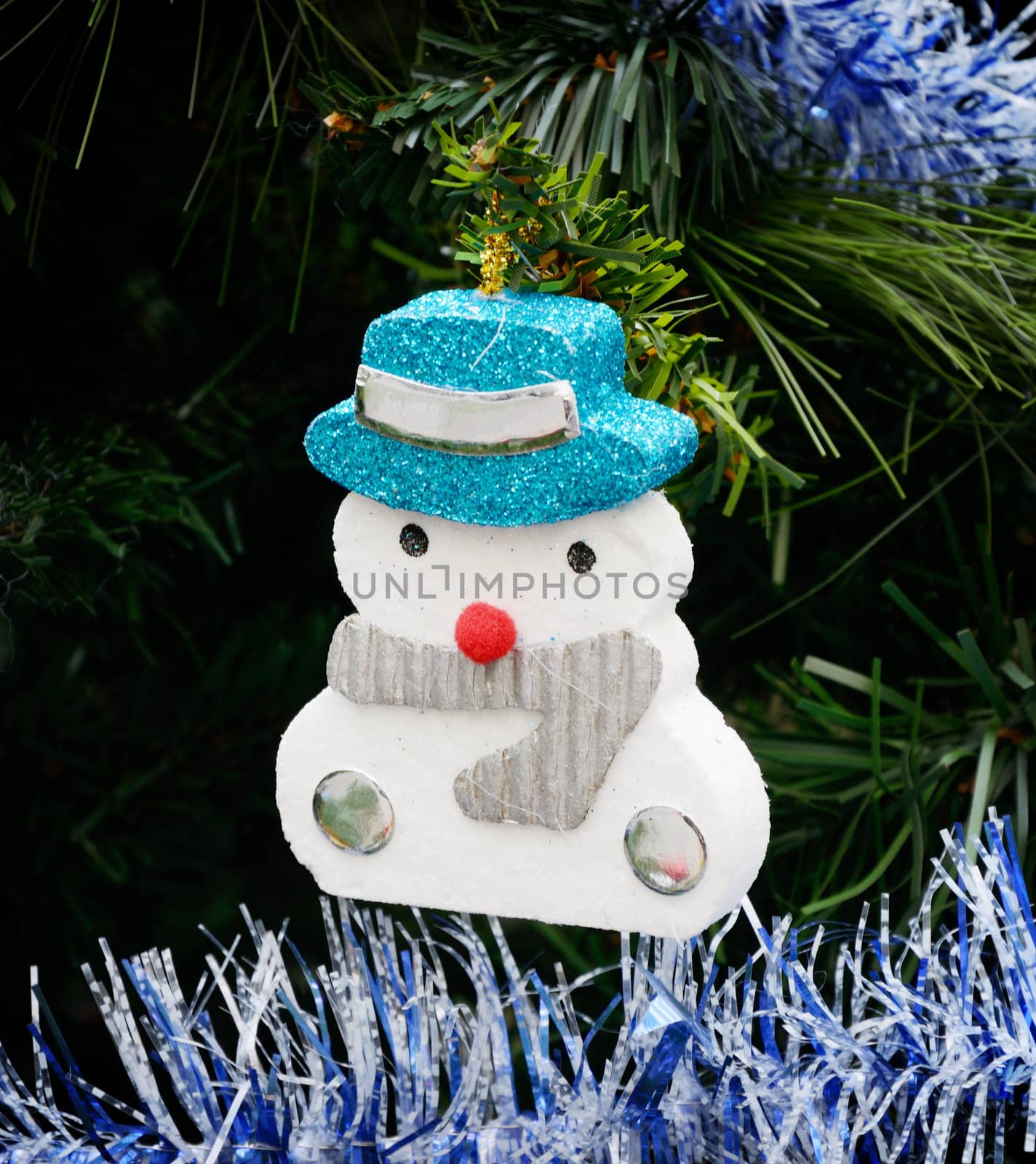 Snow man hanging art on Christmas tree with ornament by pixbox77