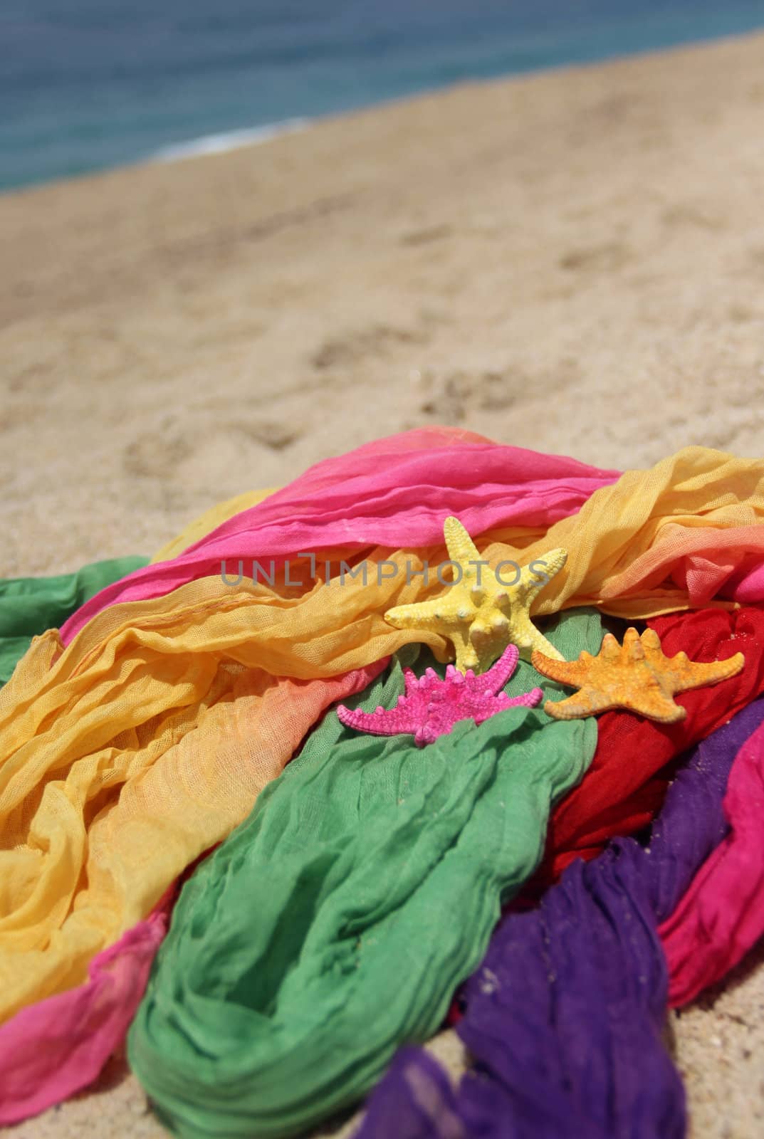 Funny starfishes on the beach and vivid fabrics