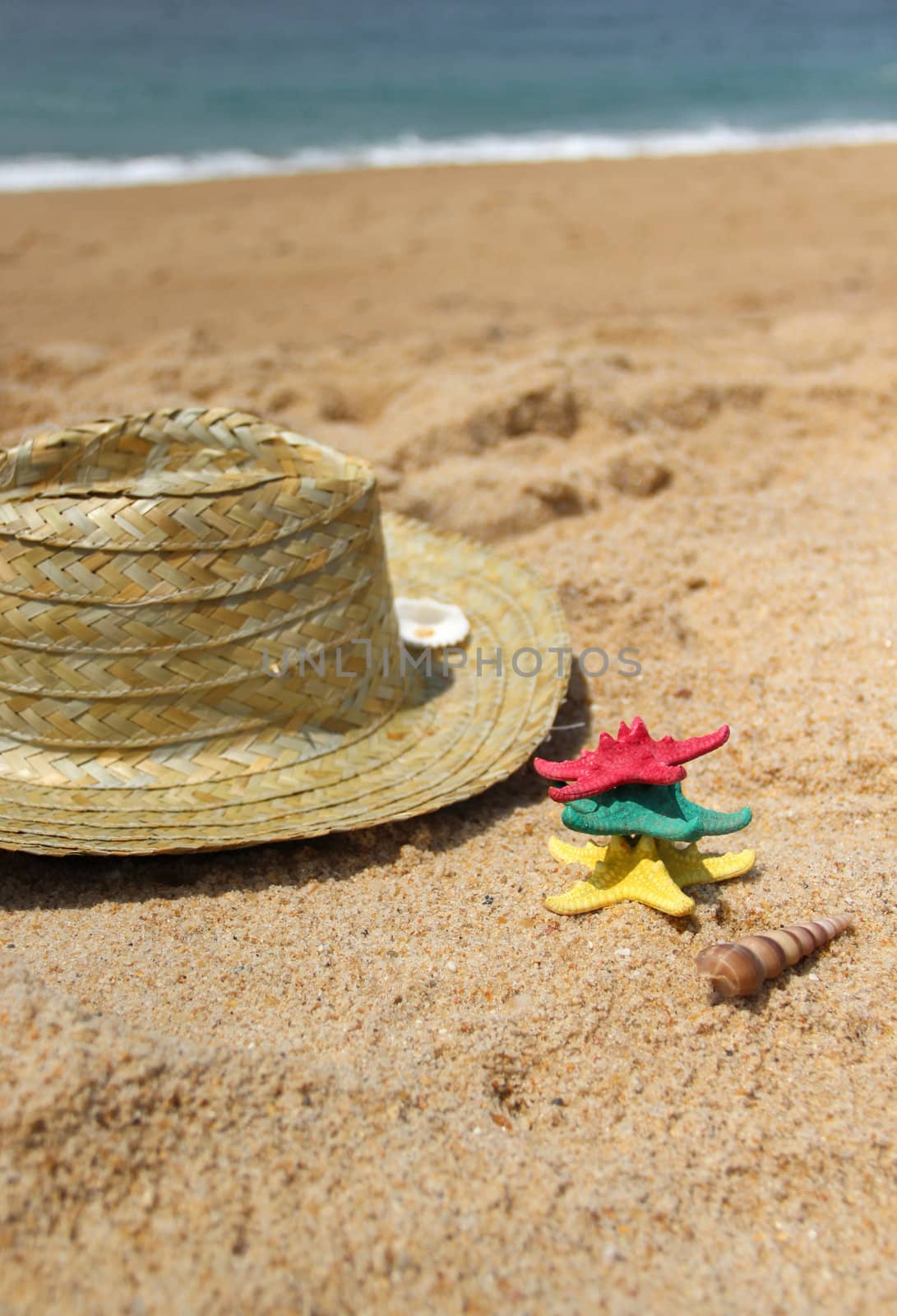 Funny starfishes on the beach and straw hat