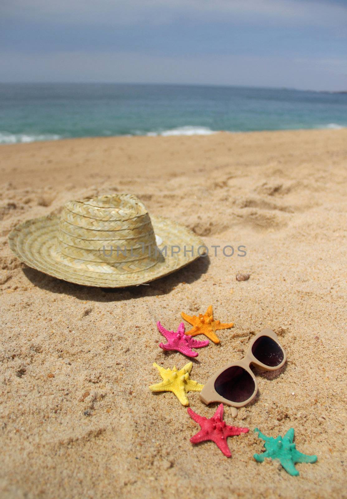 Beach items, sand and funny vivid starfishes 