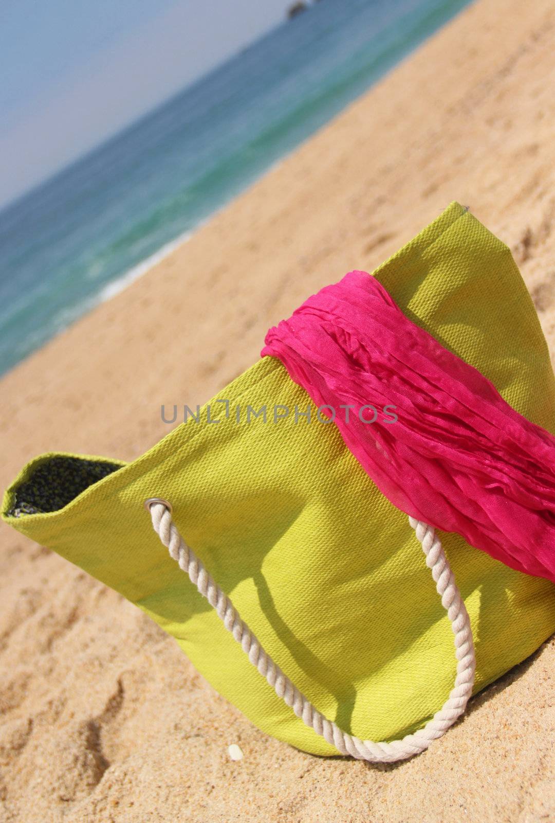 Sea time composition: green beach bag on the beach