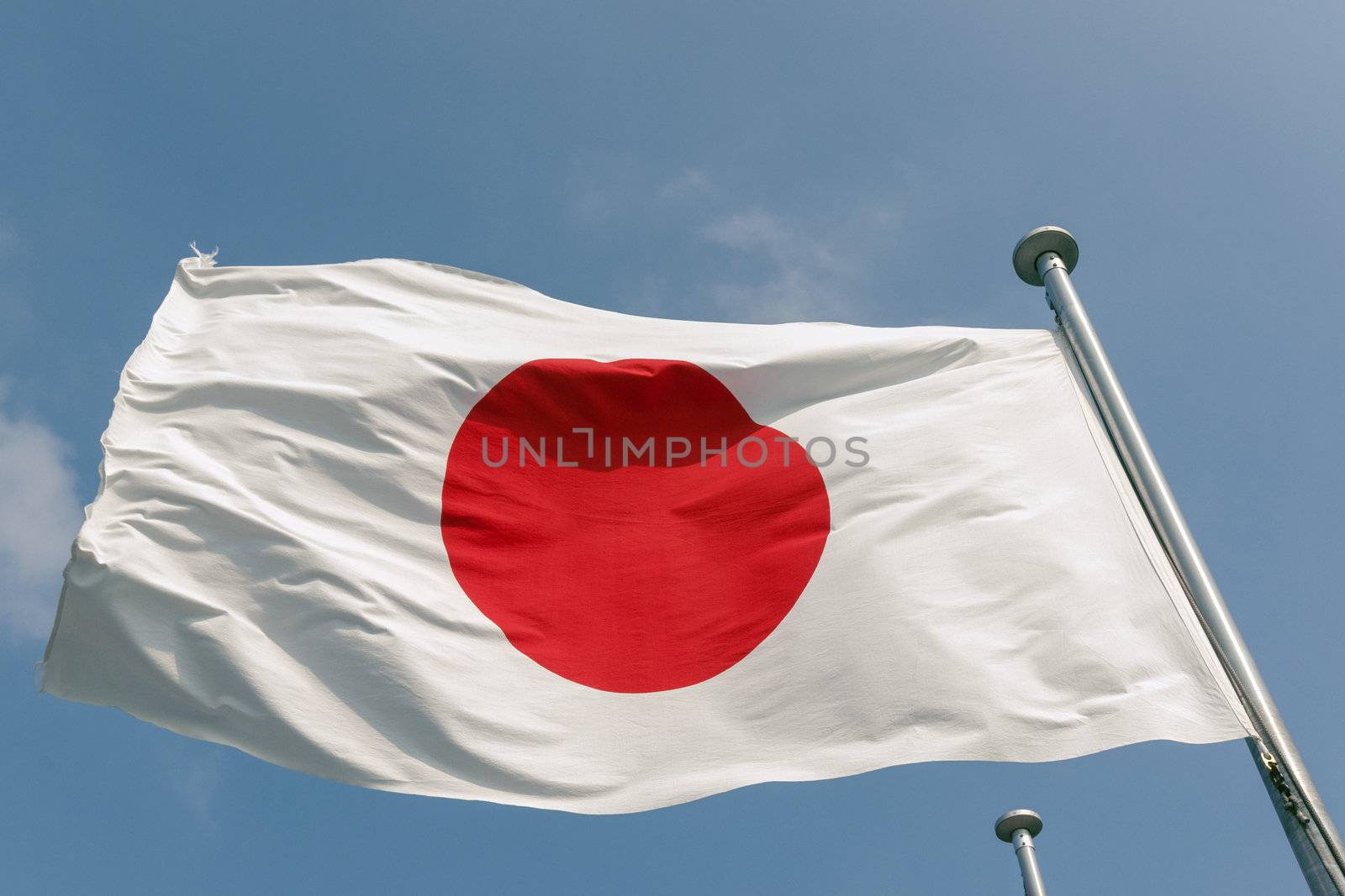 state Japanese flag on the strong wind over blue sky background