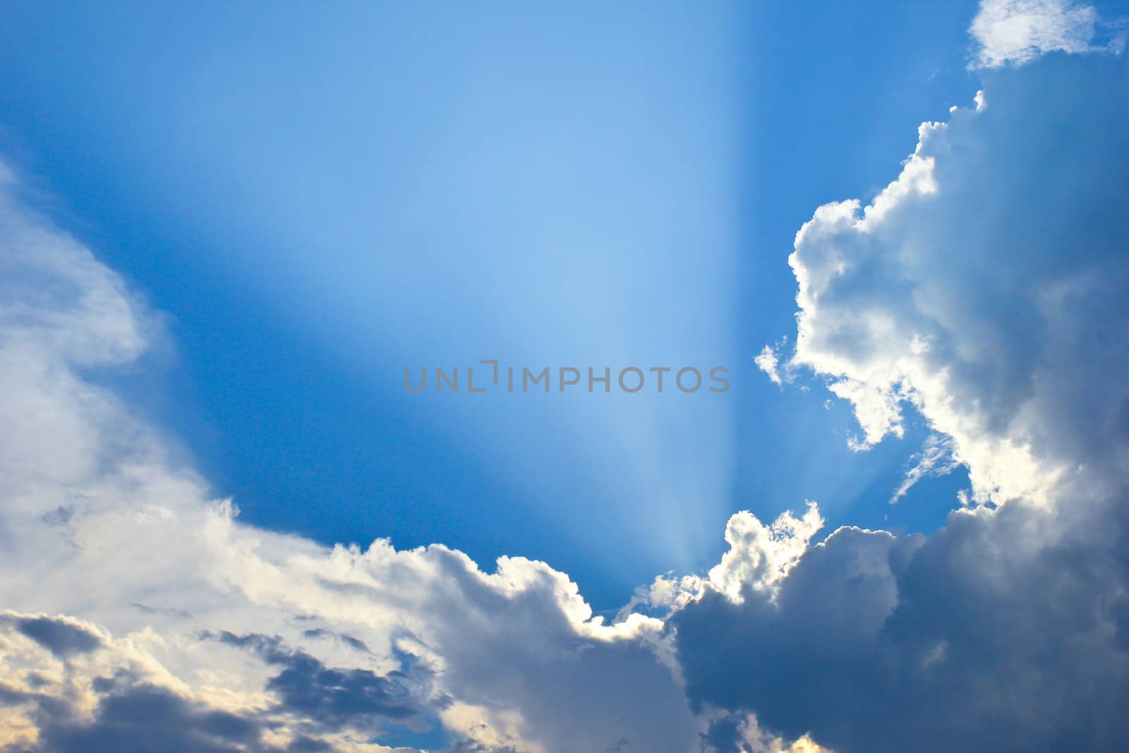 Dramatic blue sky with clouds and sunbeams