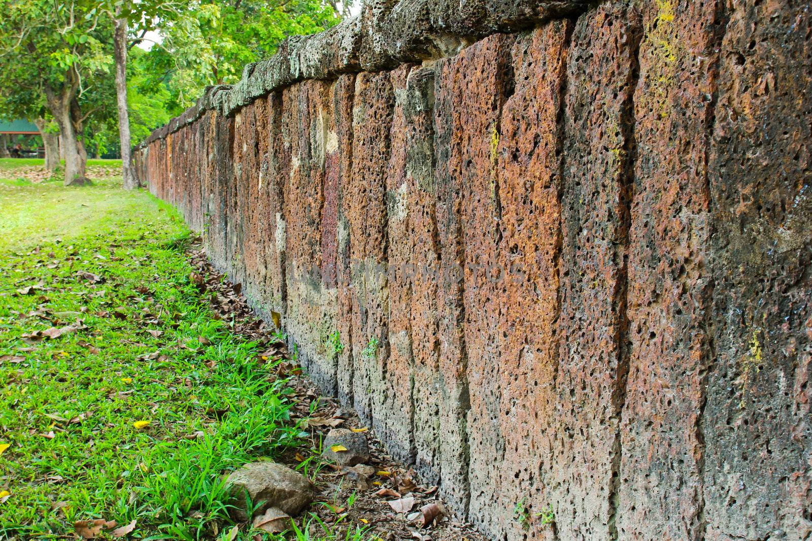 Stone block wall with green grass by nuchylee