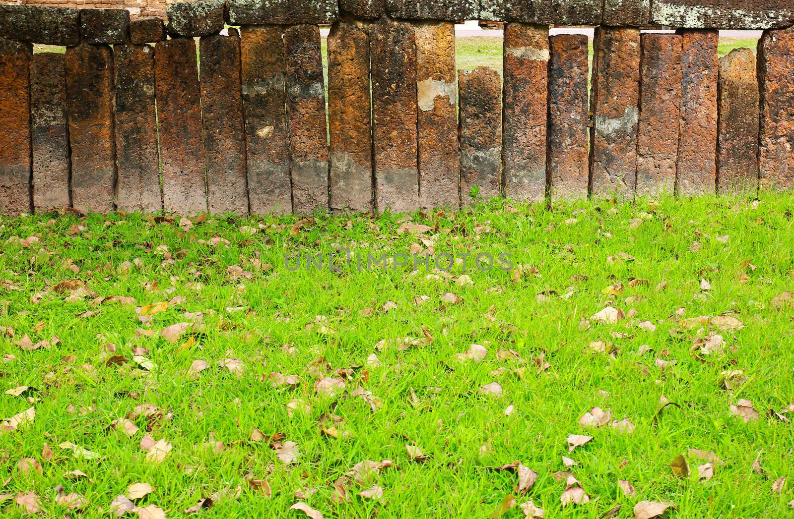 Stone block wall with green grass by nuchylee