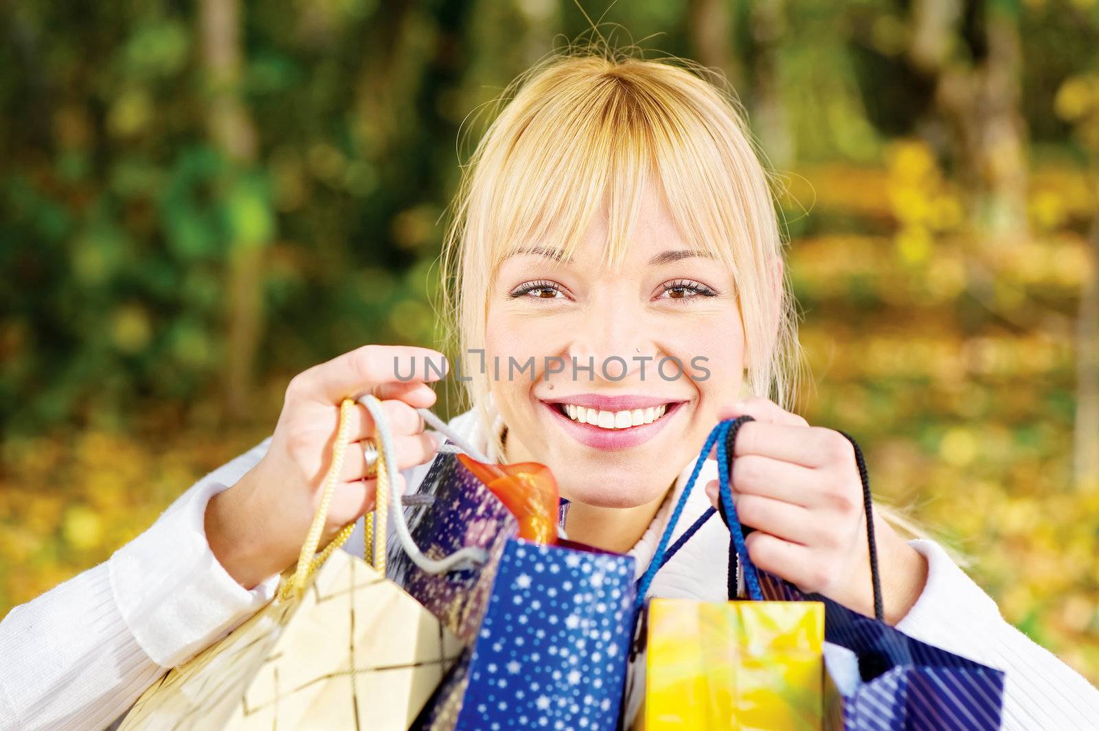 Satisfied woman with bags after shopping in park