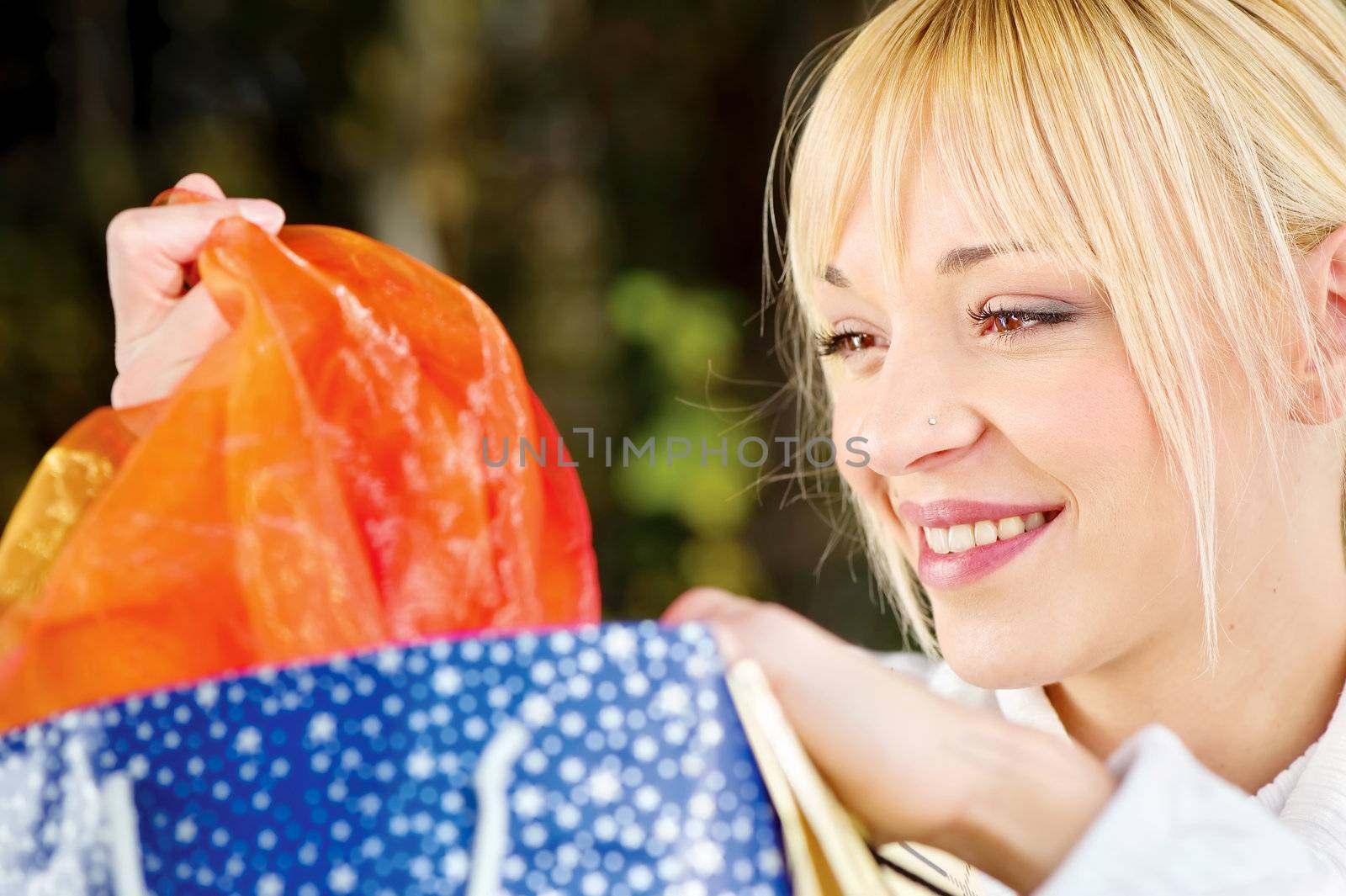 Woman looking at bag content after shopping, outdoor
