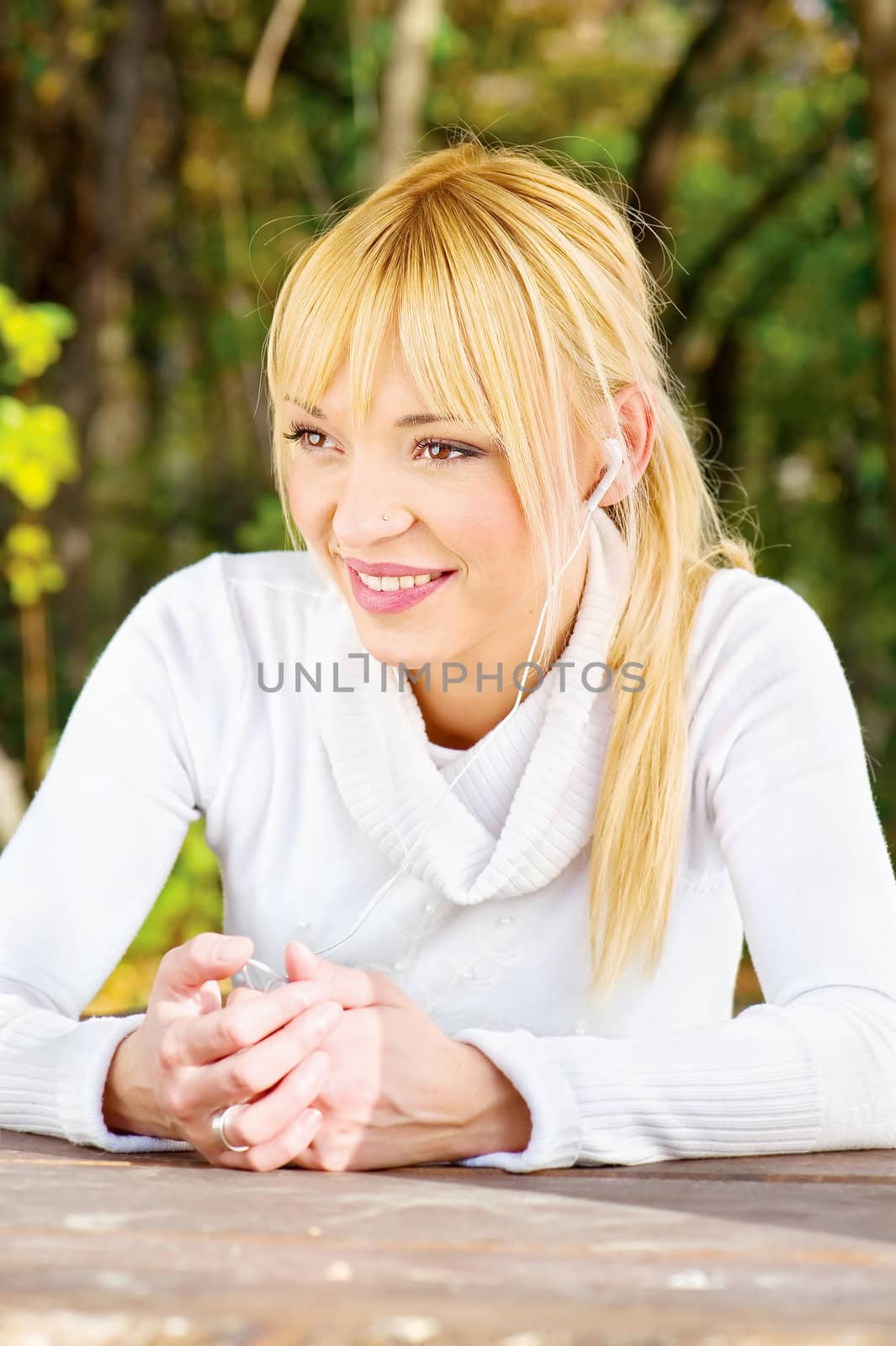 Blond woman with headphones in park