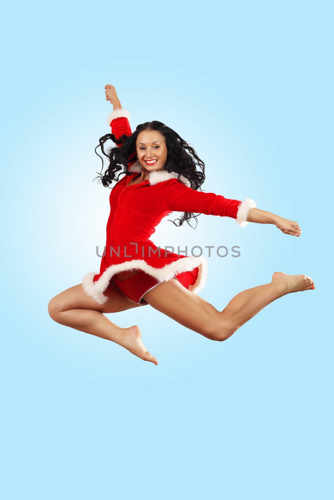 Happy smiling woman in red xmas costume jumping high