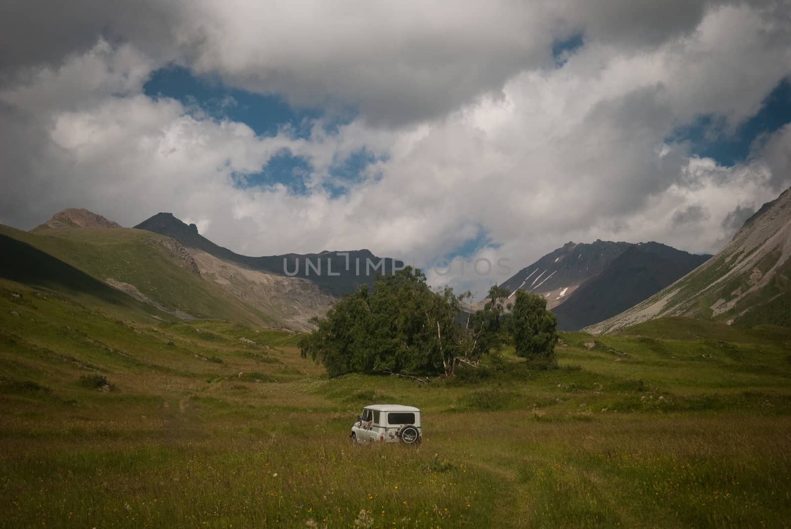 White off-road car in Caucasian Mountains in summer