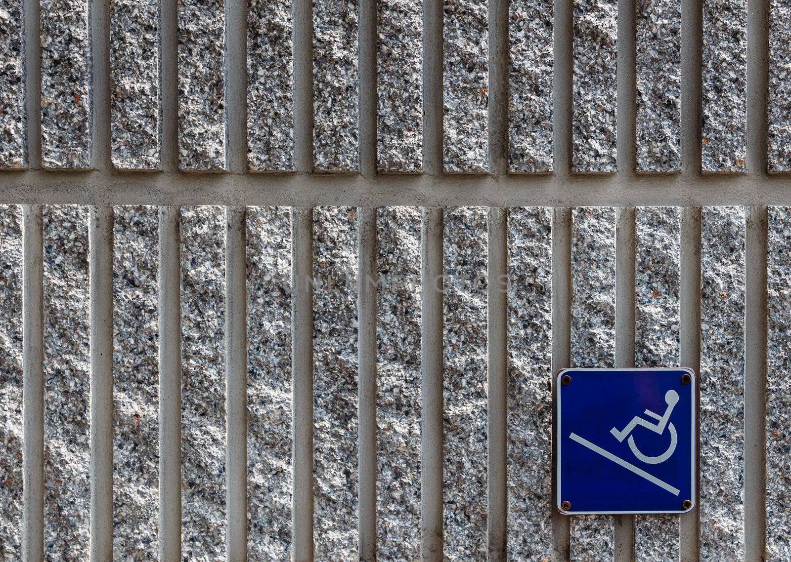 Ramp access sign for the disabled on concrete wall background