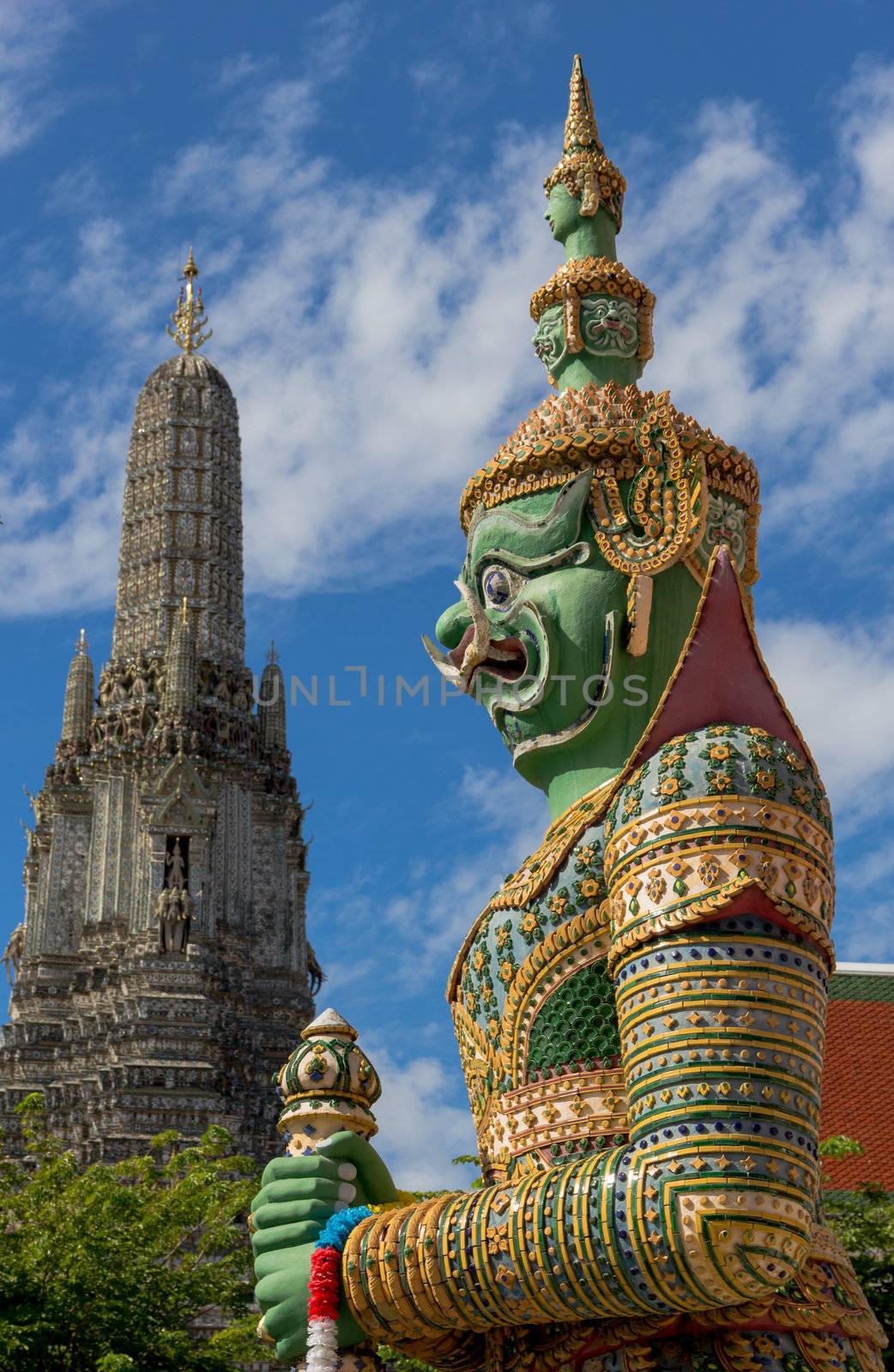 Guardian statue at the Temple of Dawn was beautifully decorated with tiny pieces of colored ceramics and Chinese porcelain placed delicately into intricate patterns. It is one of Bangkok's world-famous landmarks.