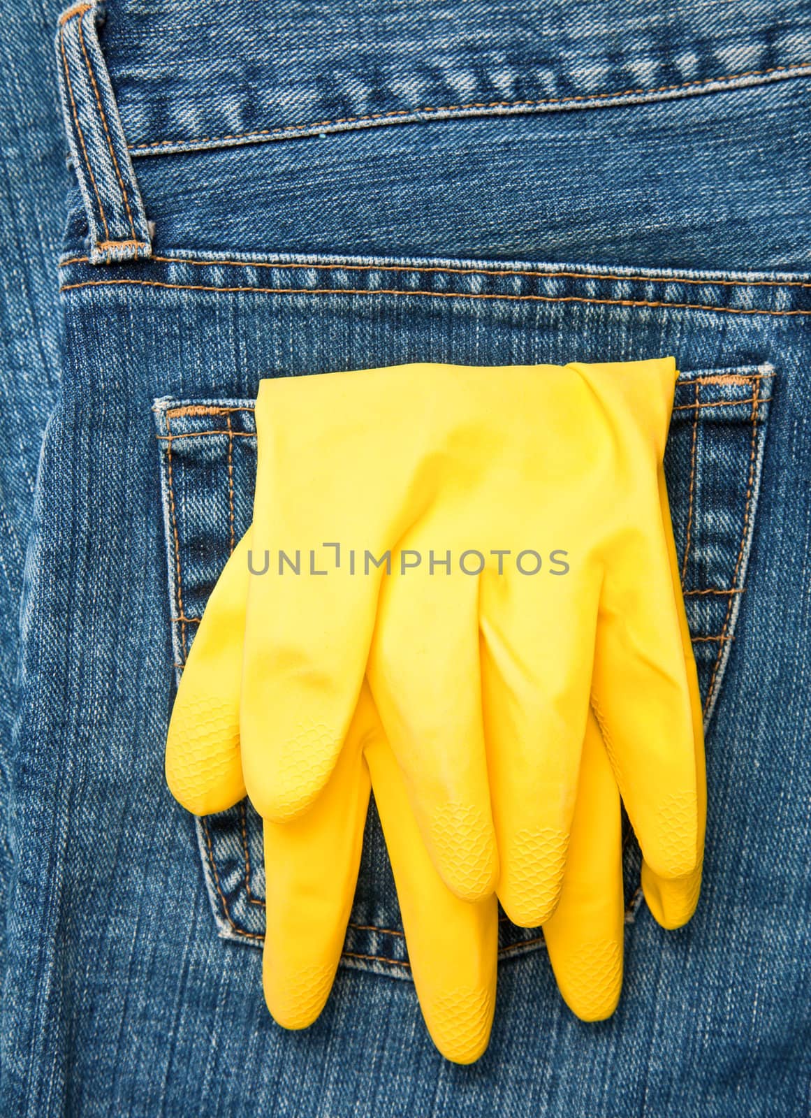 Blue jeans pocket with yellow protective gloves