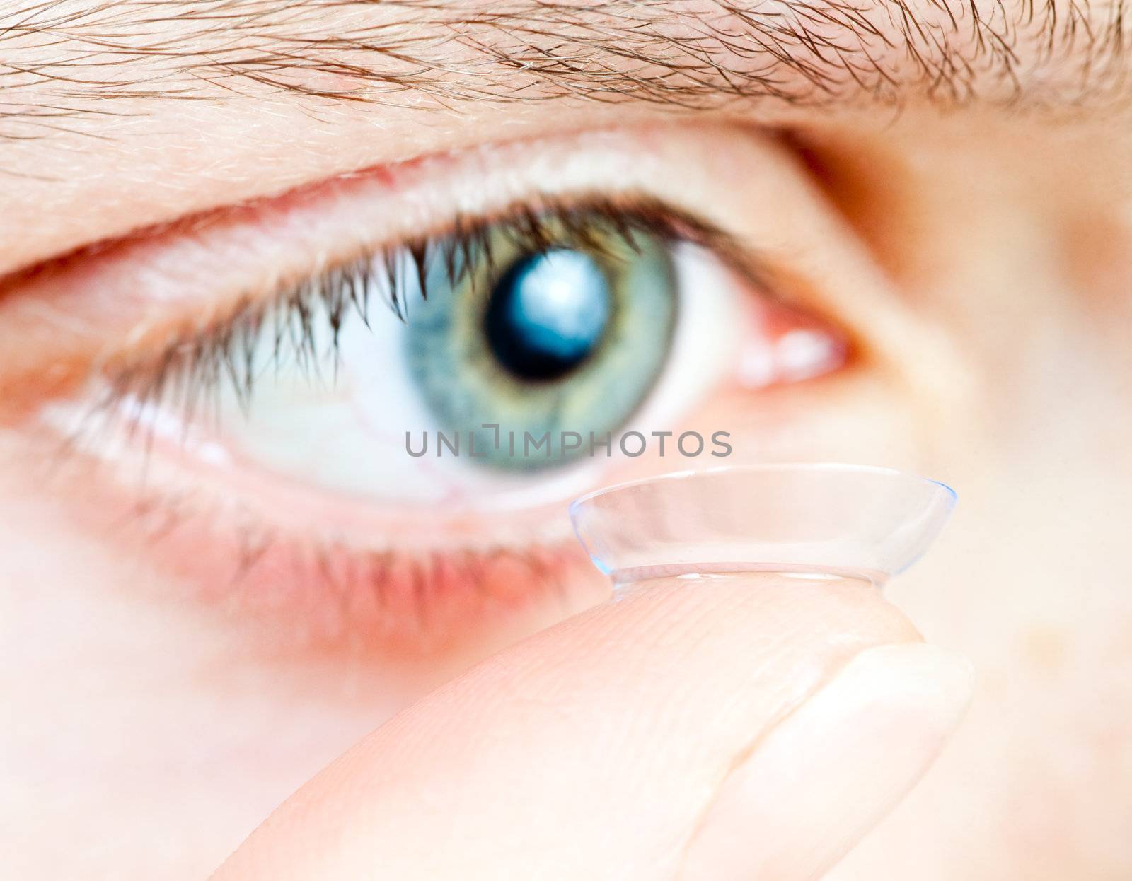 Young woman Inserting a contact lens closeup, shallow focus