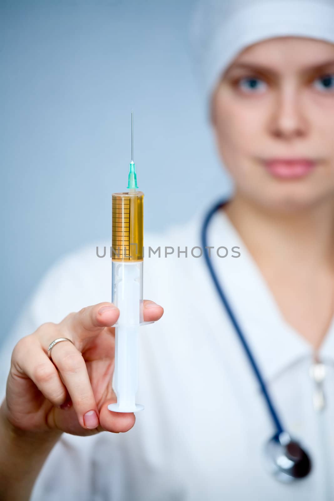 Doctor holding big syringe with yellow liquid, focus on syringe