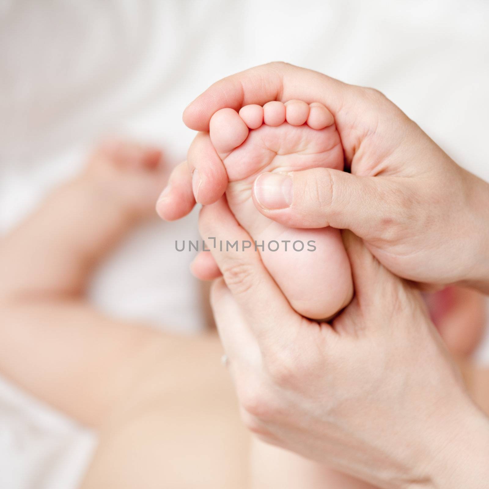Mother massaging her child's foot, shallow focus