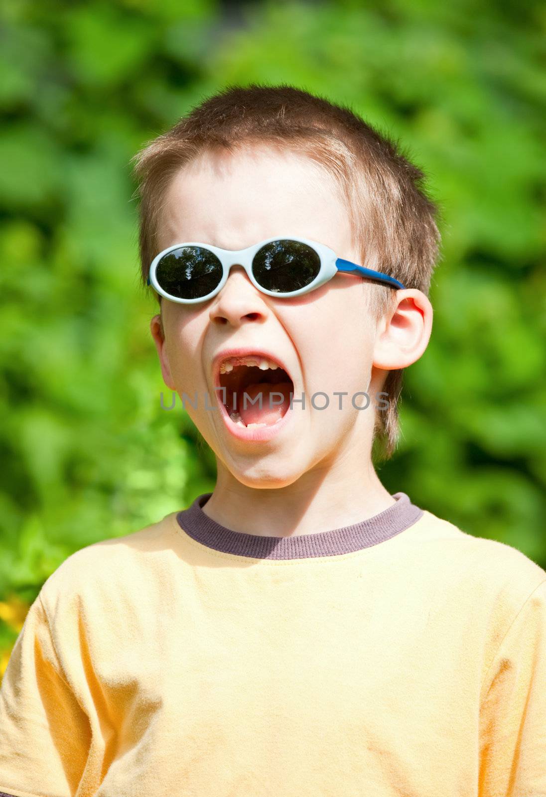 Young boy wearing sunglasses yelling
