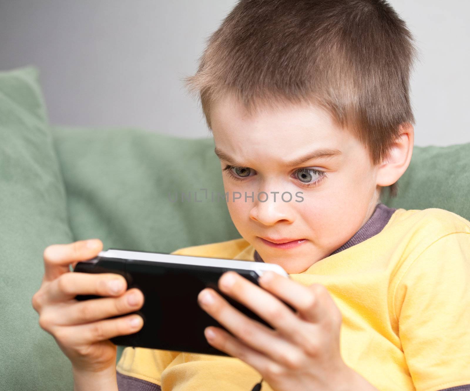 Boy playing game console by naumoid
