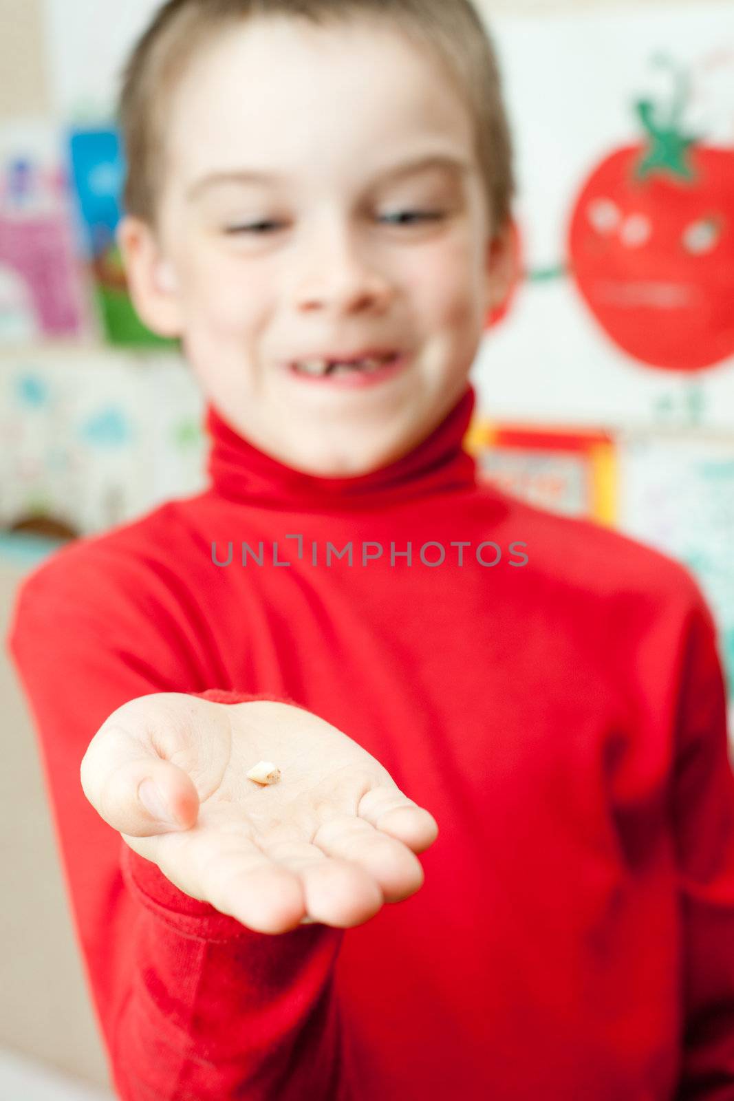 Boy with deciduous tooth in his hand, shallow focus