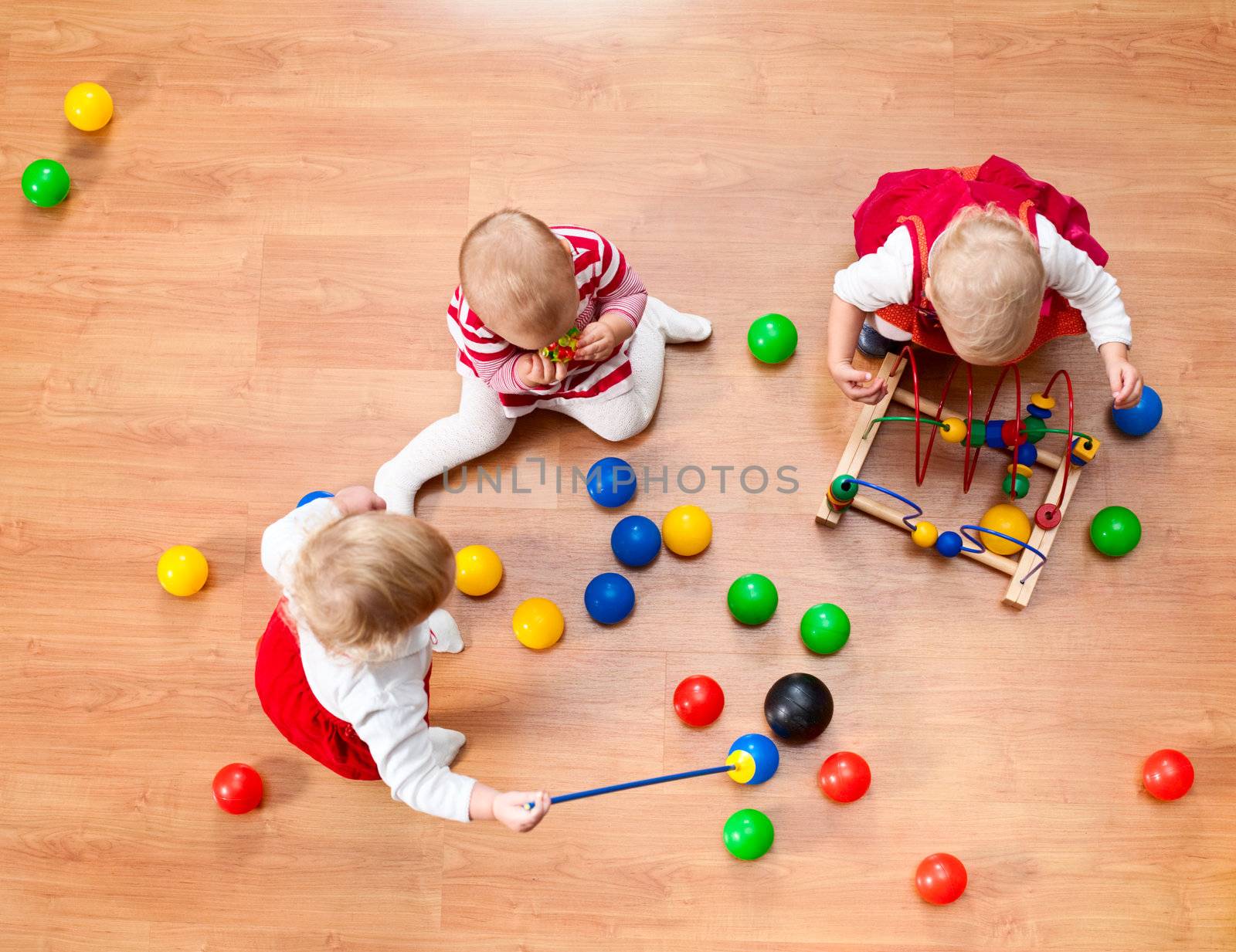 Top view of three little girls playing on the floor