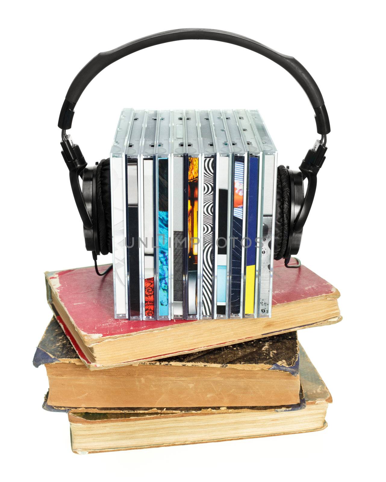 Stack of CDs with HI-Fi headphones and old books on white background