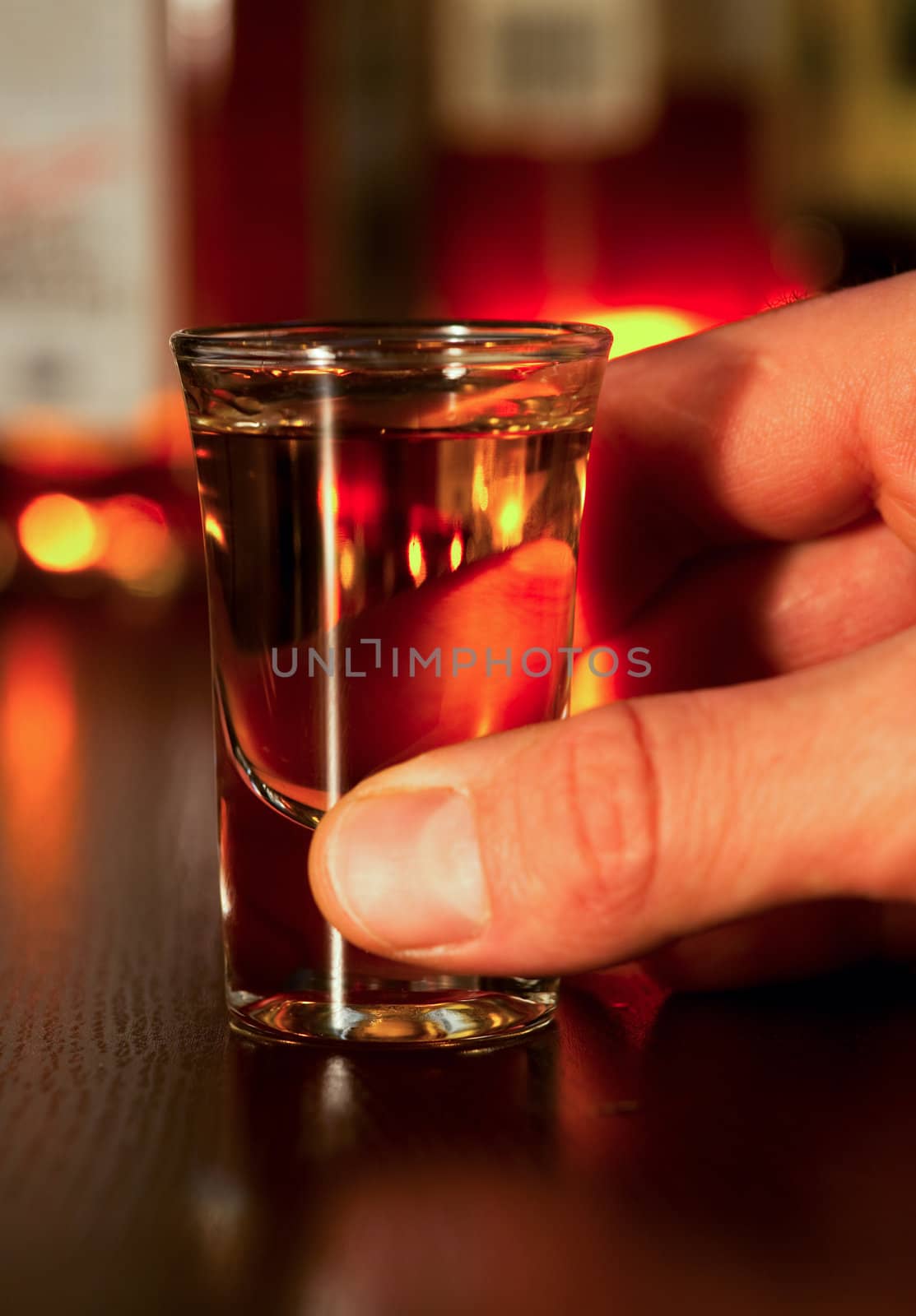 Hand holding whiskey shot, shallow focus