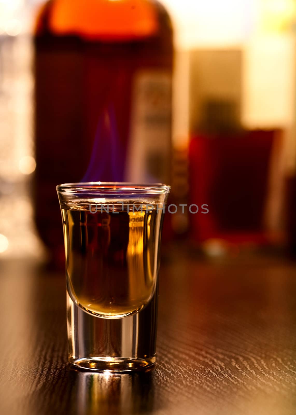 Burning cocktail in shot glass on a table, shallow focus