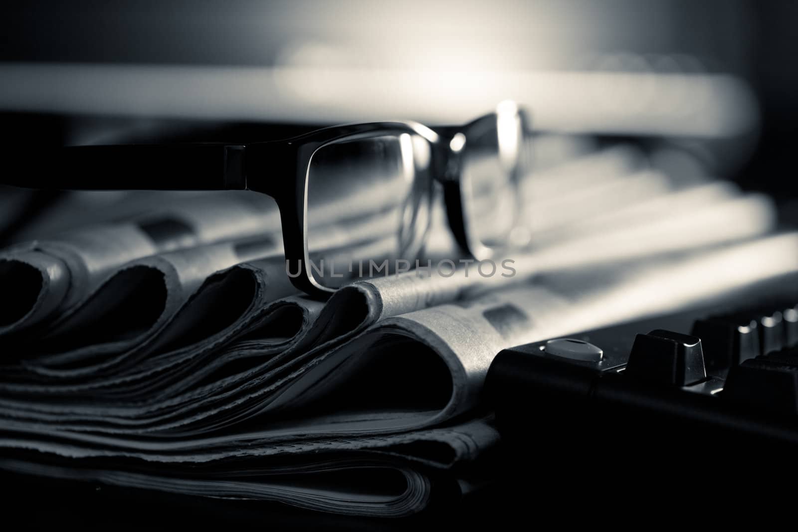 Glasses on stack of newspapers, very shallow focus