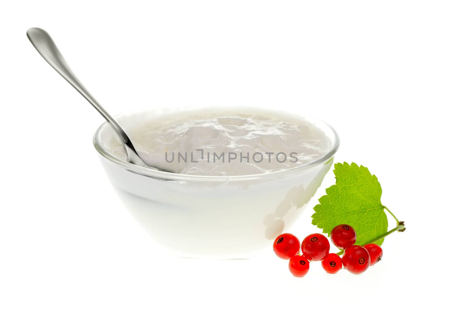 Yogurt bowl with spoon and Redcurrant berries on white background