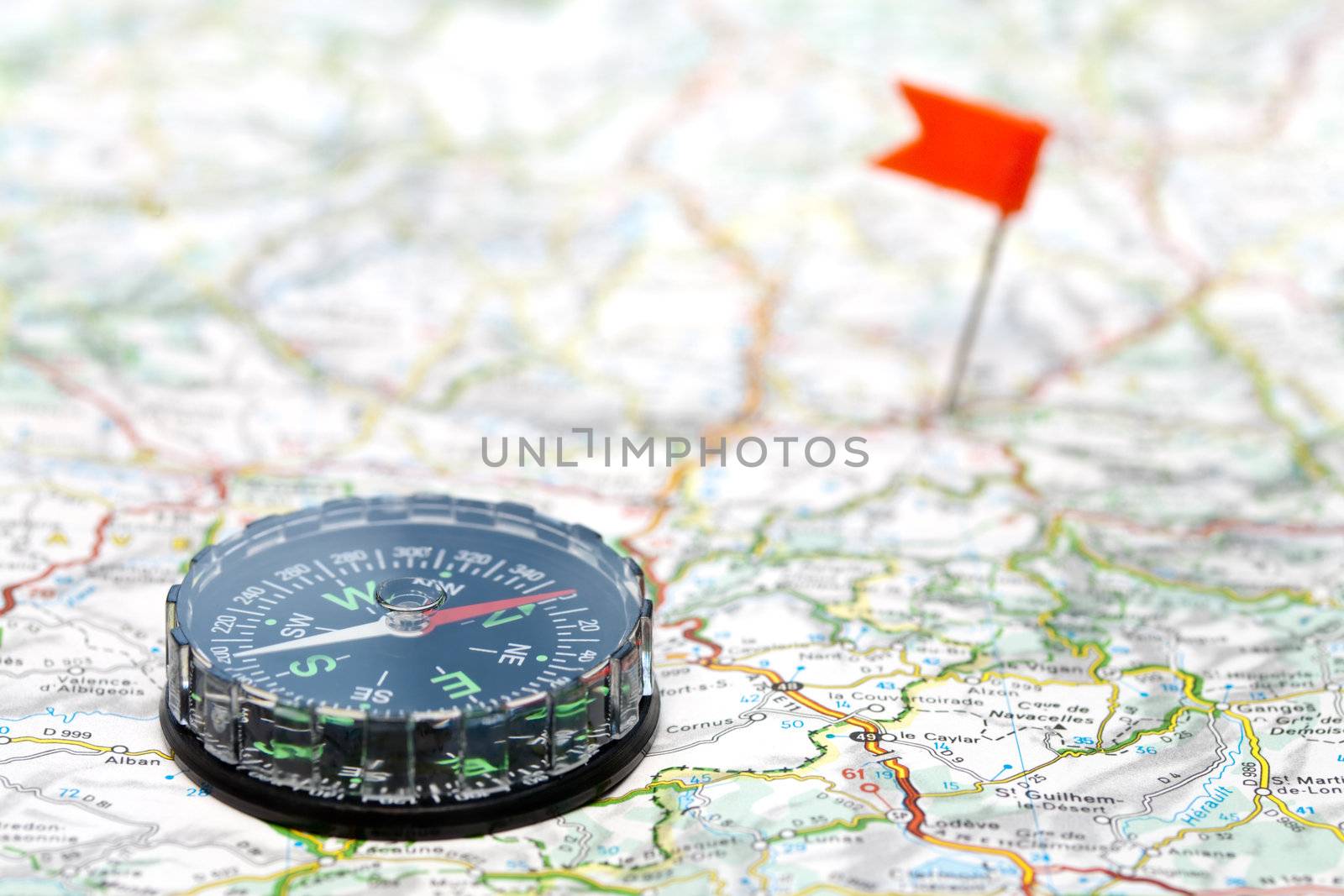 Compass on map with color flag pin in background