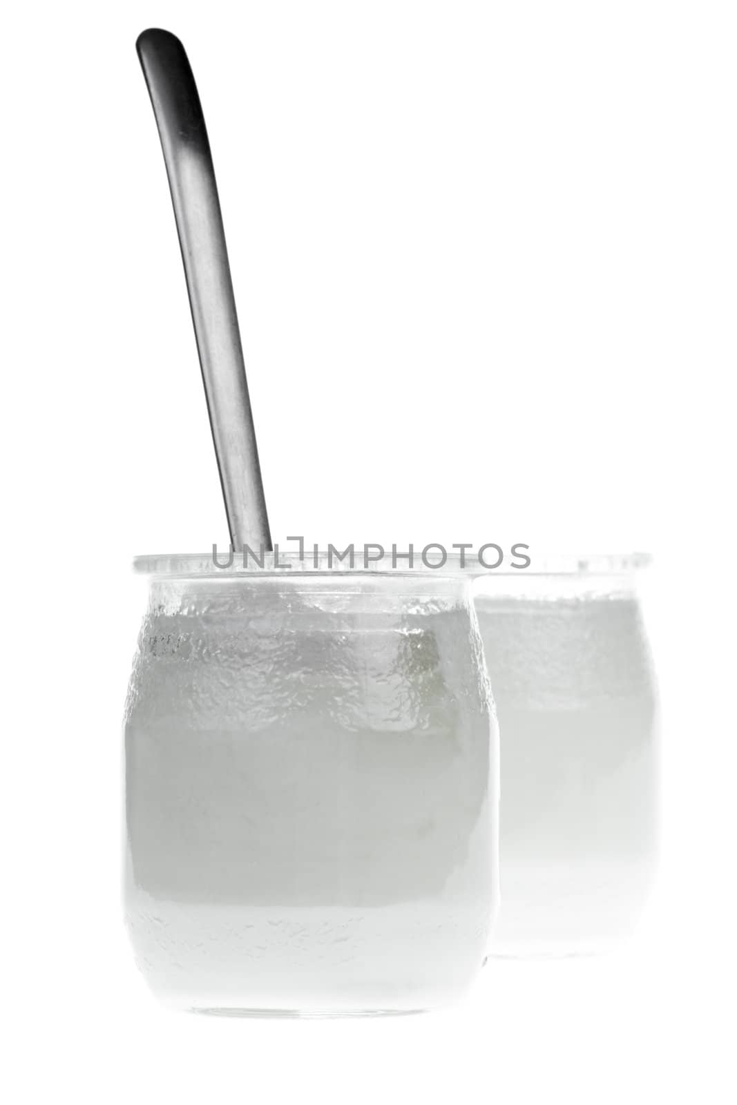 Old-fashioned yogurt jars with spoon on white background