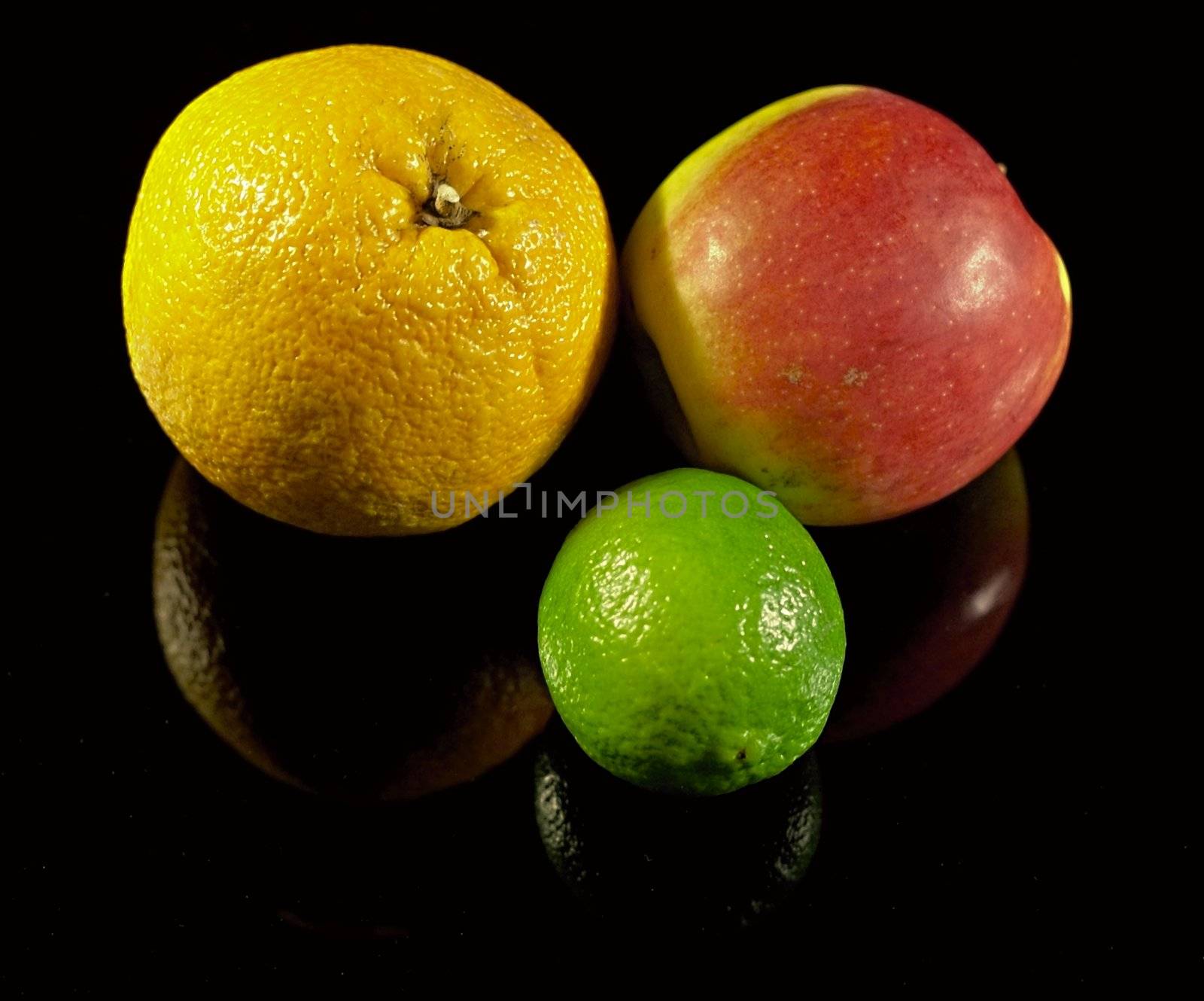 Apple,lemon and orange on black desk with shadows