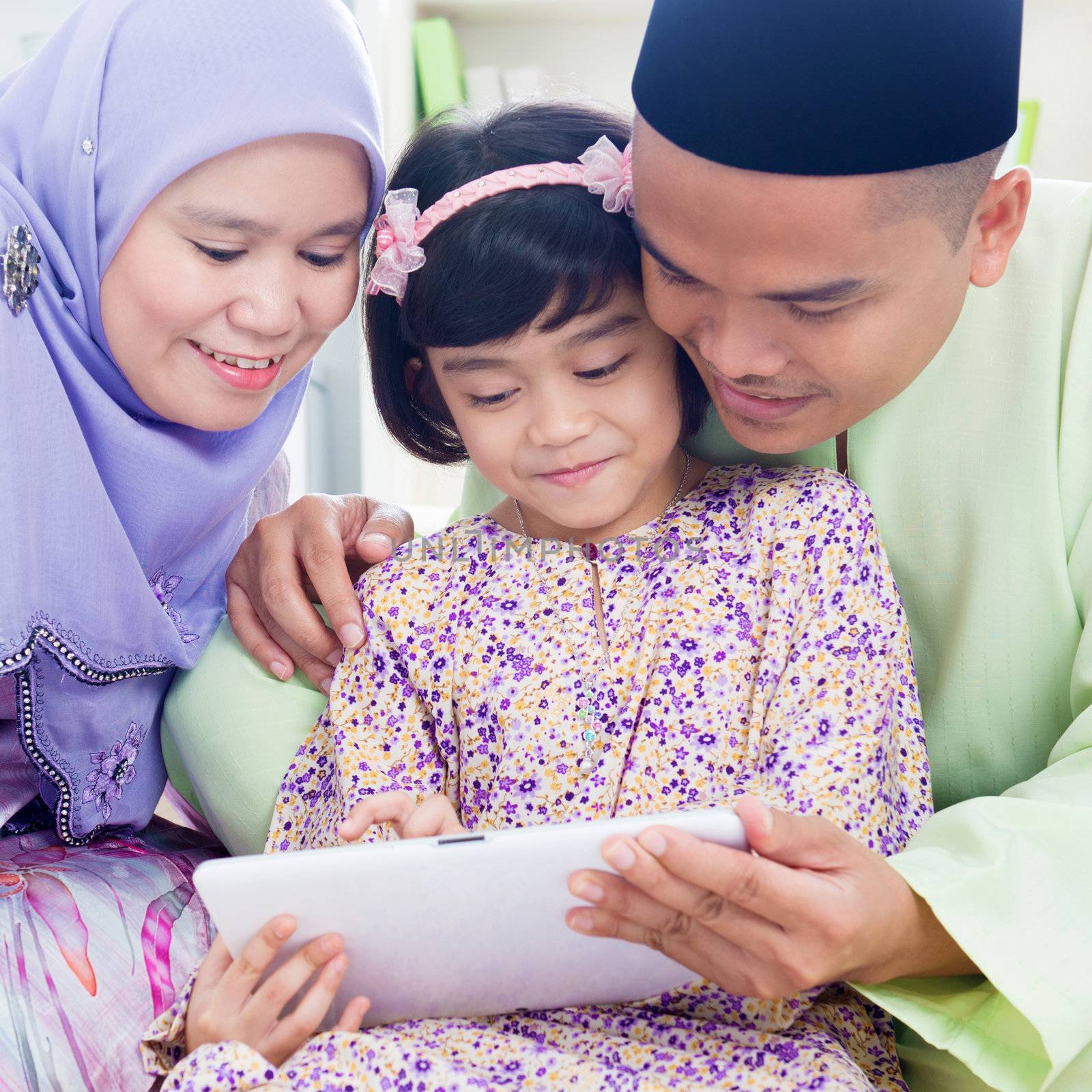 Southeast Asian family surfing internet at home. Muslim family living lifestyle