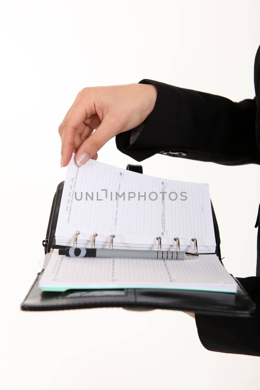 A cropped picture of a businesswoman holding a planner. by phovoir