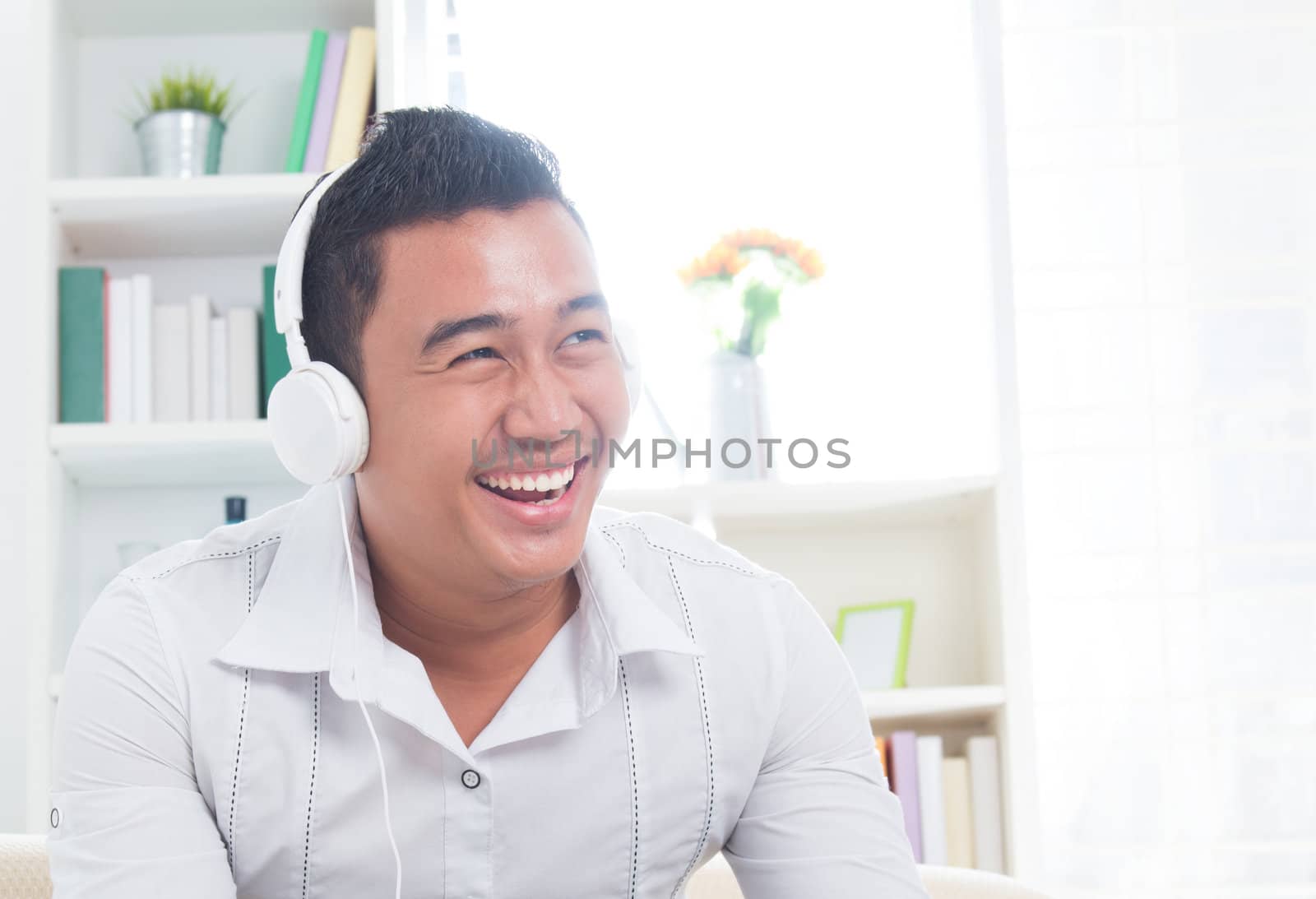 Attractive Southeast Asian man listen mp3 at home