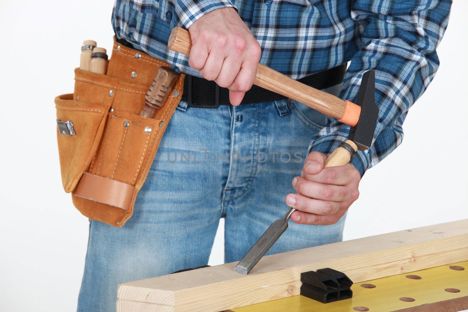 Tradesman chiseling a plank of wood by phovoir