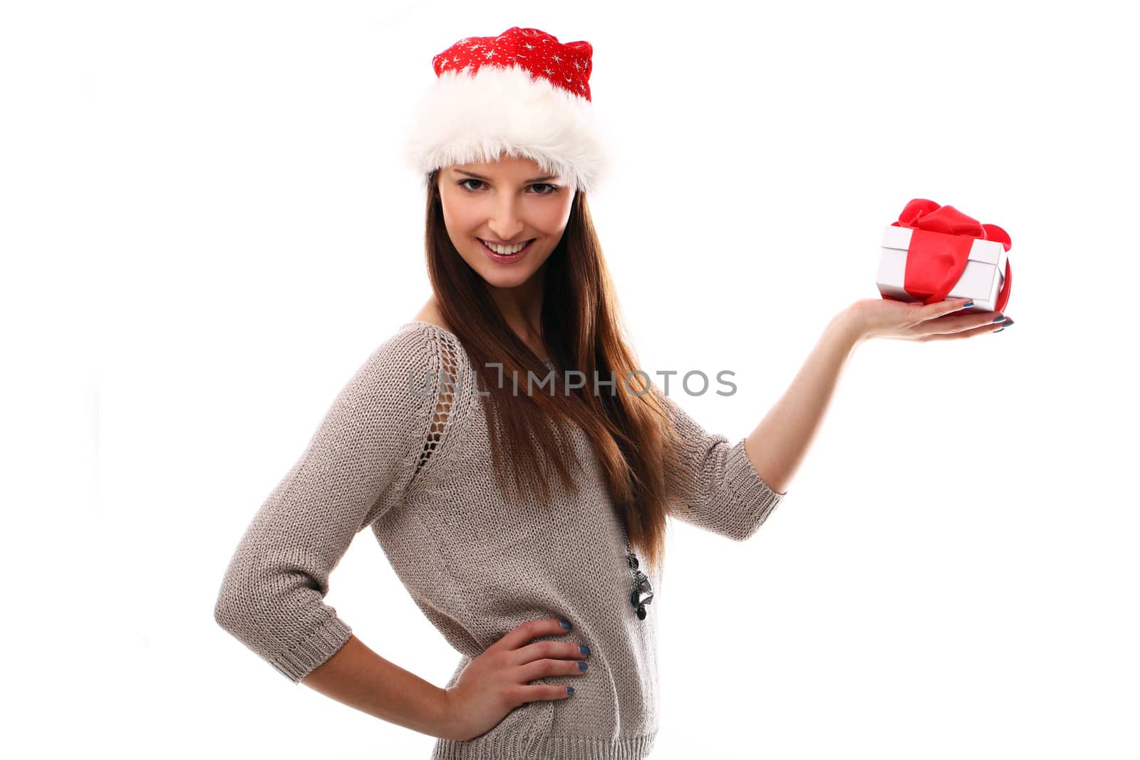 Beautiful girl smiling in christmas hat and holding gift over a white background