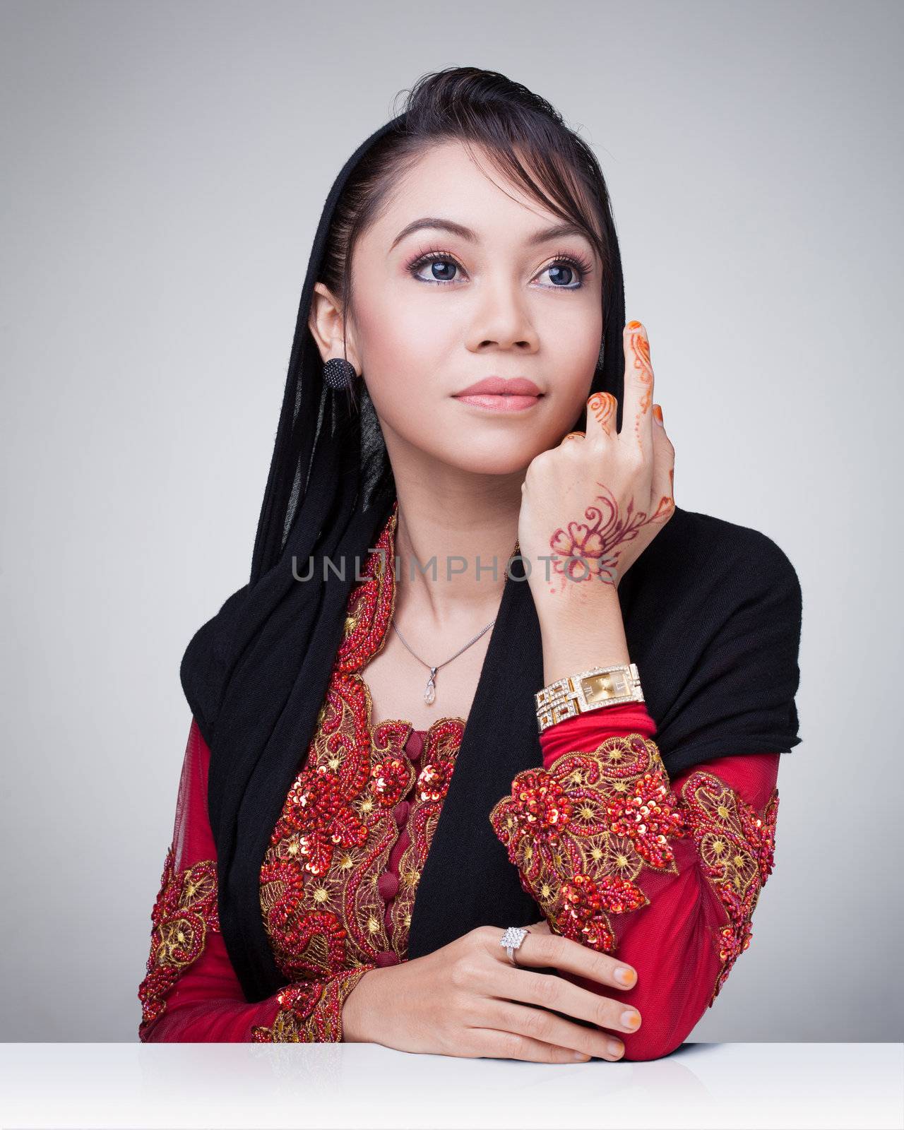 Beautiful muslim lady wear red with hijab, henna painted on hand