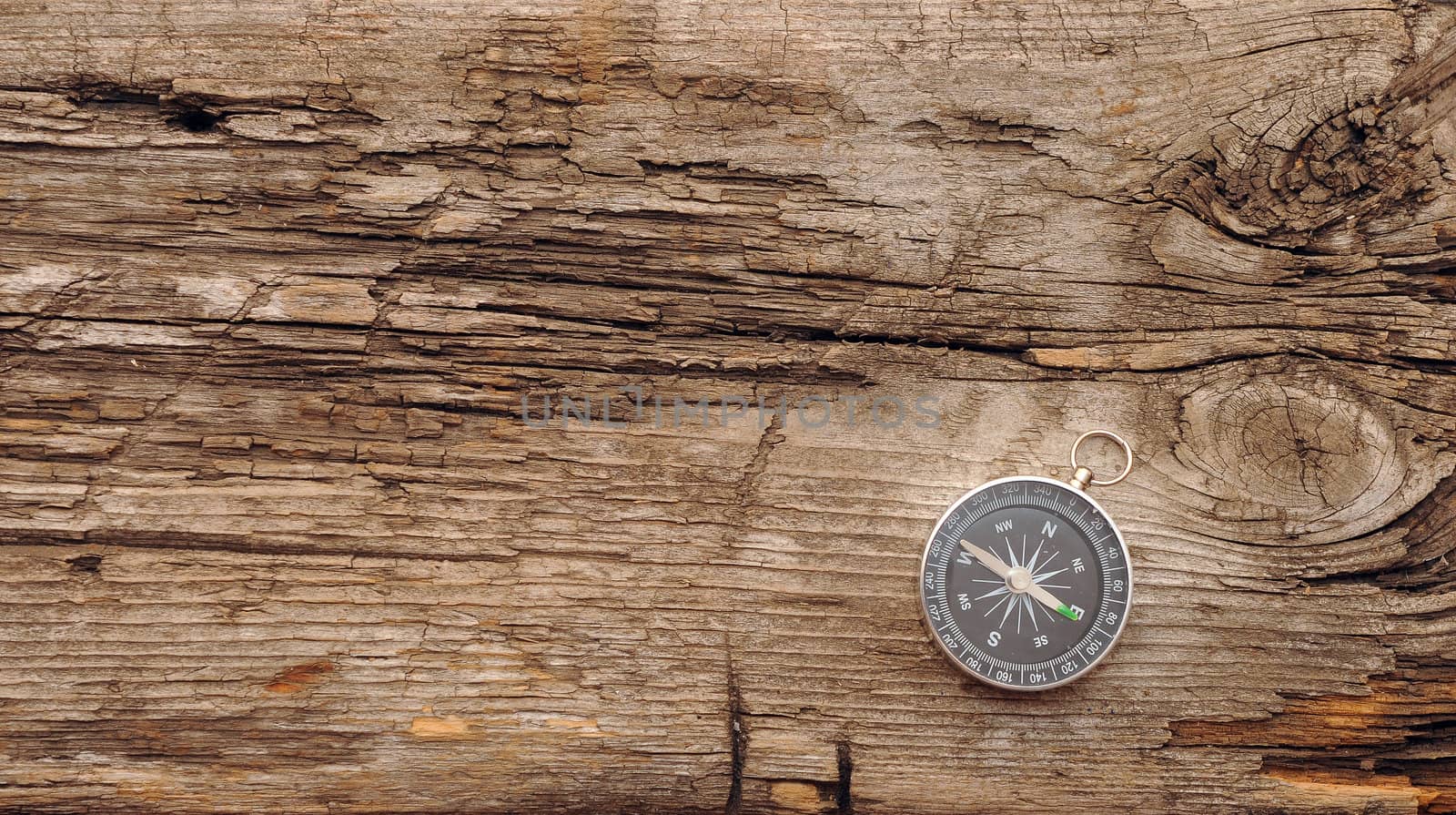 Compass on the old wooden background 