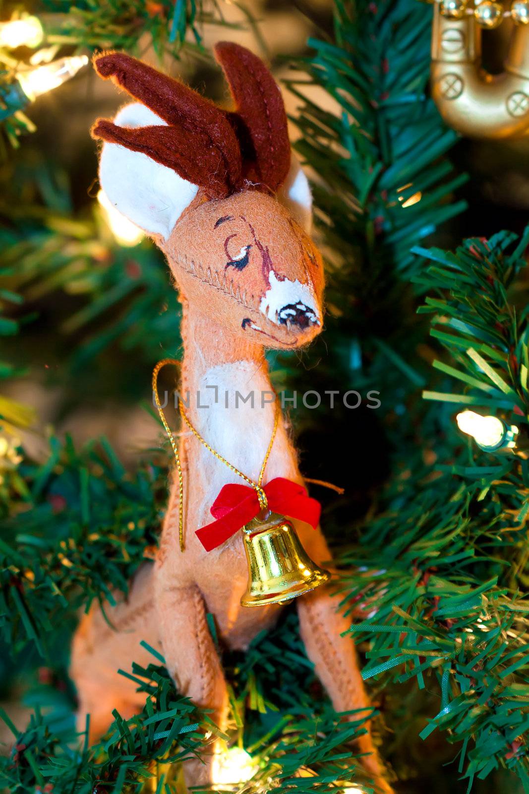 Xmas deer with a bell on its neck on the tree