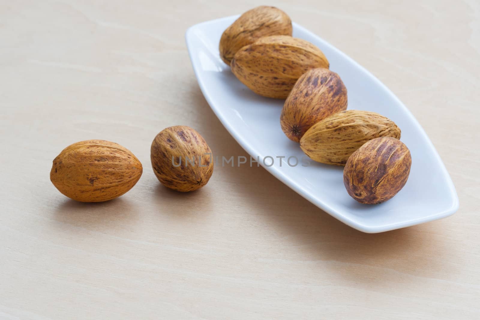 brown nuts lying in a row on a platter by sfinks